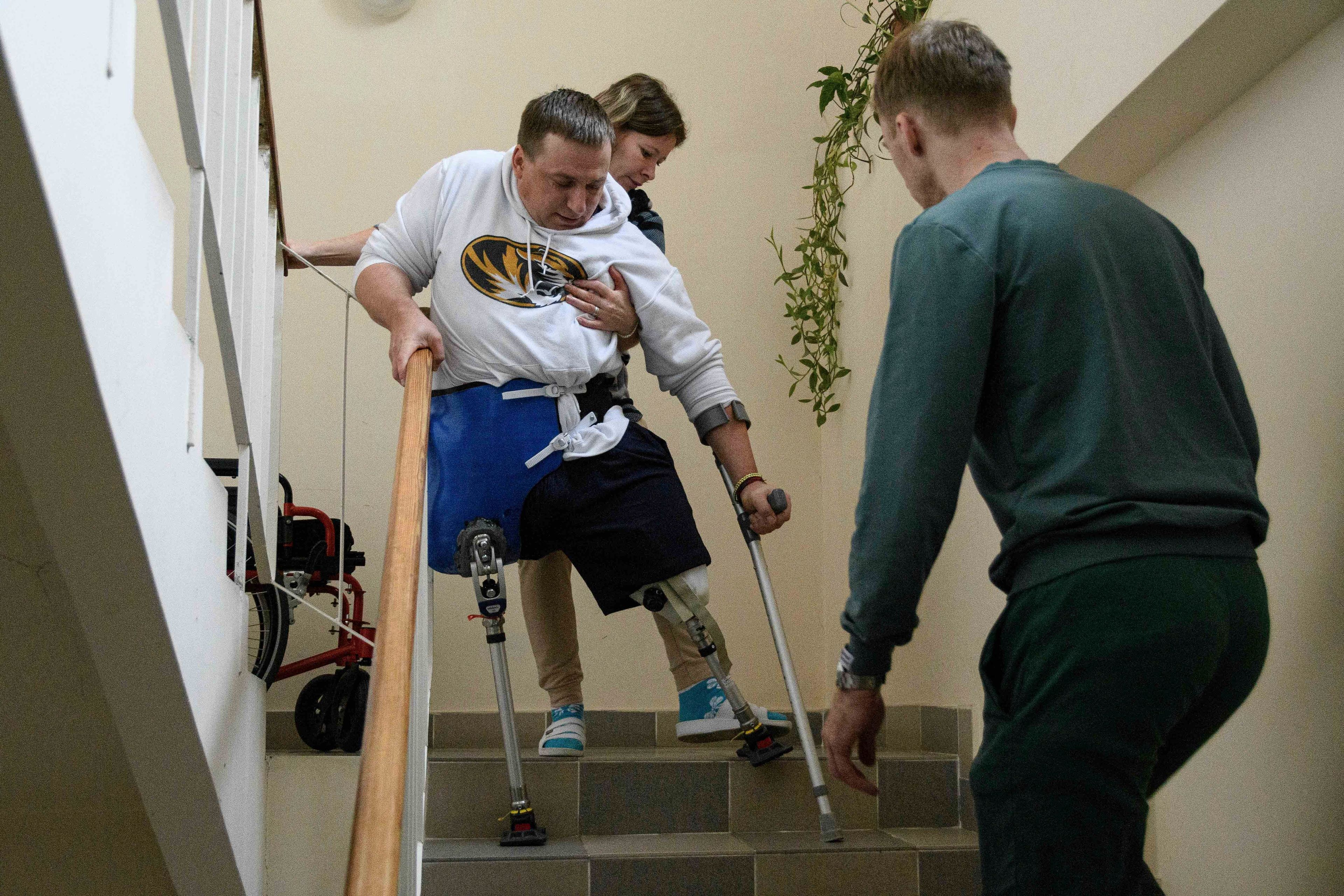 Anastasia helps husband Serhiy Ponomarenko, a Ukrainian serviceman who had two limbs amputated after fighting at the frontline, as he does his morning exercises in Halychyna rehabilitation center in Lviv, Ukraine, Nov. 11, 2024. (AP Photo/Mykola Tys)