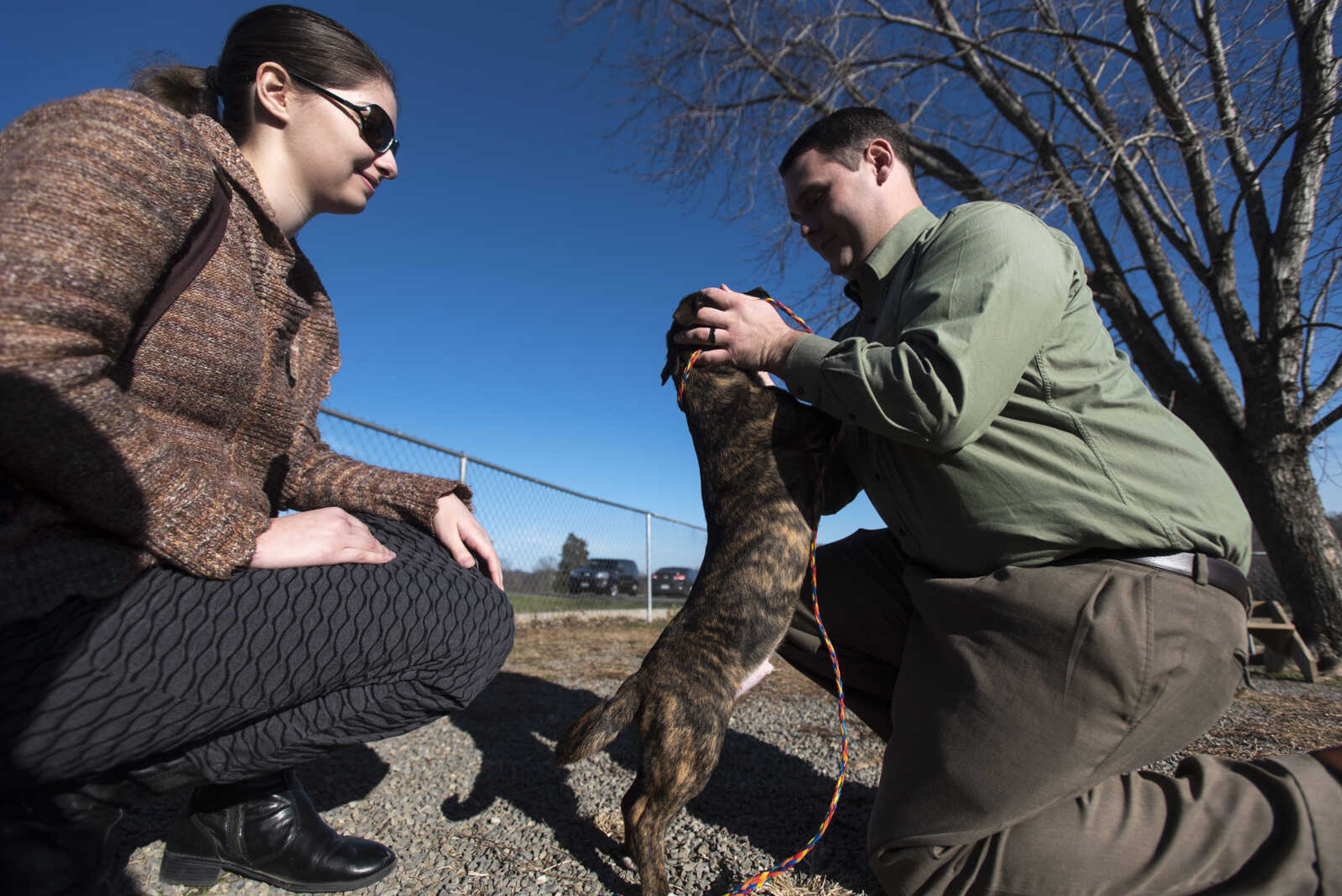 Olivia and Danny Howell play with Reese the dog at the 40th anniversary of the Humane Society of Southeast Missouri Saturday, Dec. 16 , 2017 in Cape Girardeau.