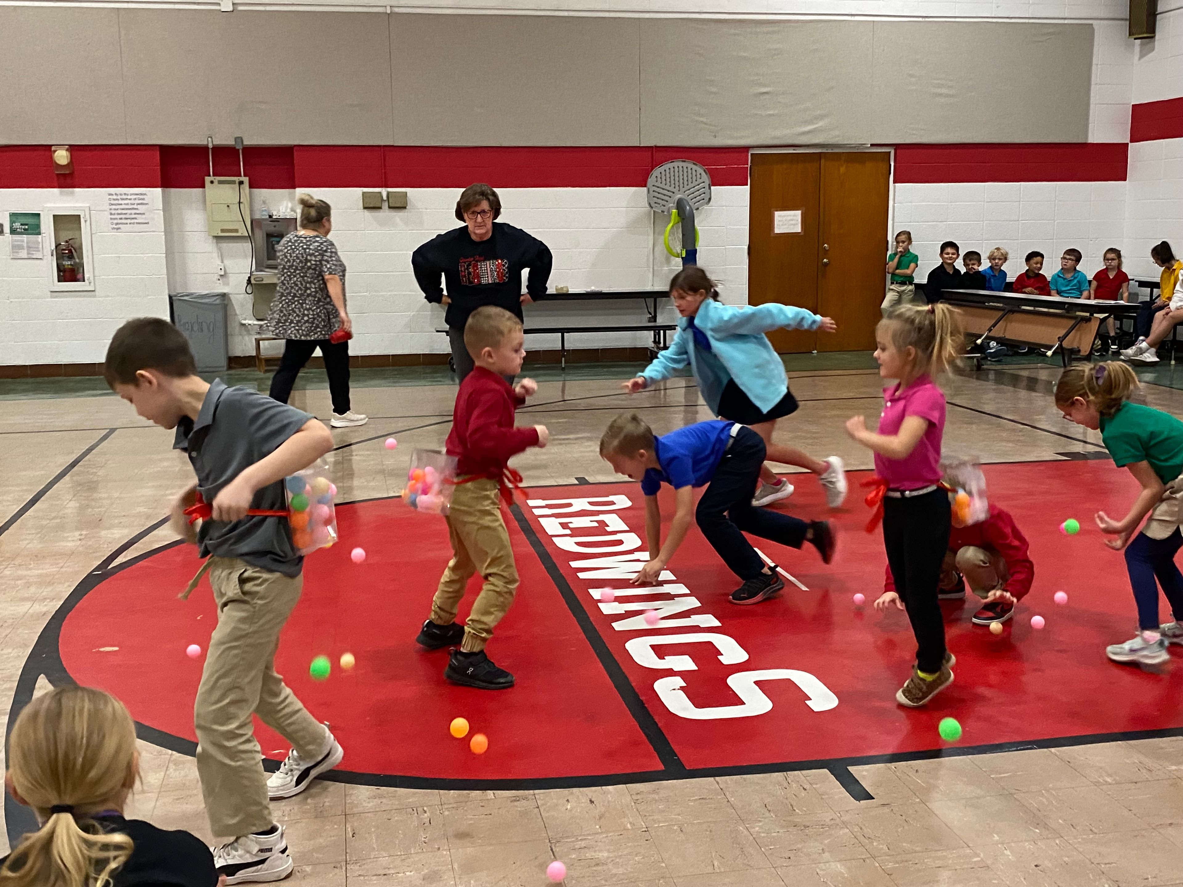 Michael Weathers, Kallon Graviett, & Peyton Dirnberger of St. Michael's house work at emptying out their box filled with balls.  Other St. Michael members run around picking up the loose balls.  The students in St. Michael's house that are pictured are Laynie Priggel, Fisher Gadberry, and Berkley Dennis.
