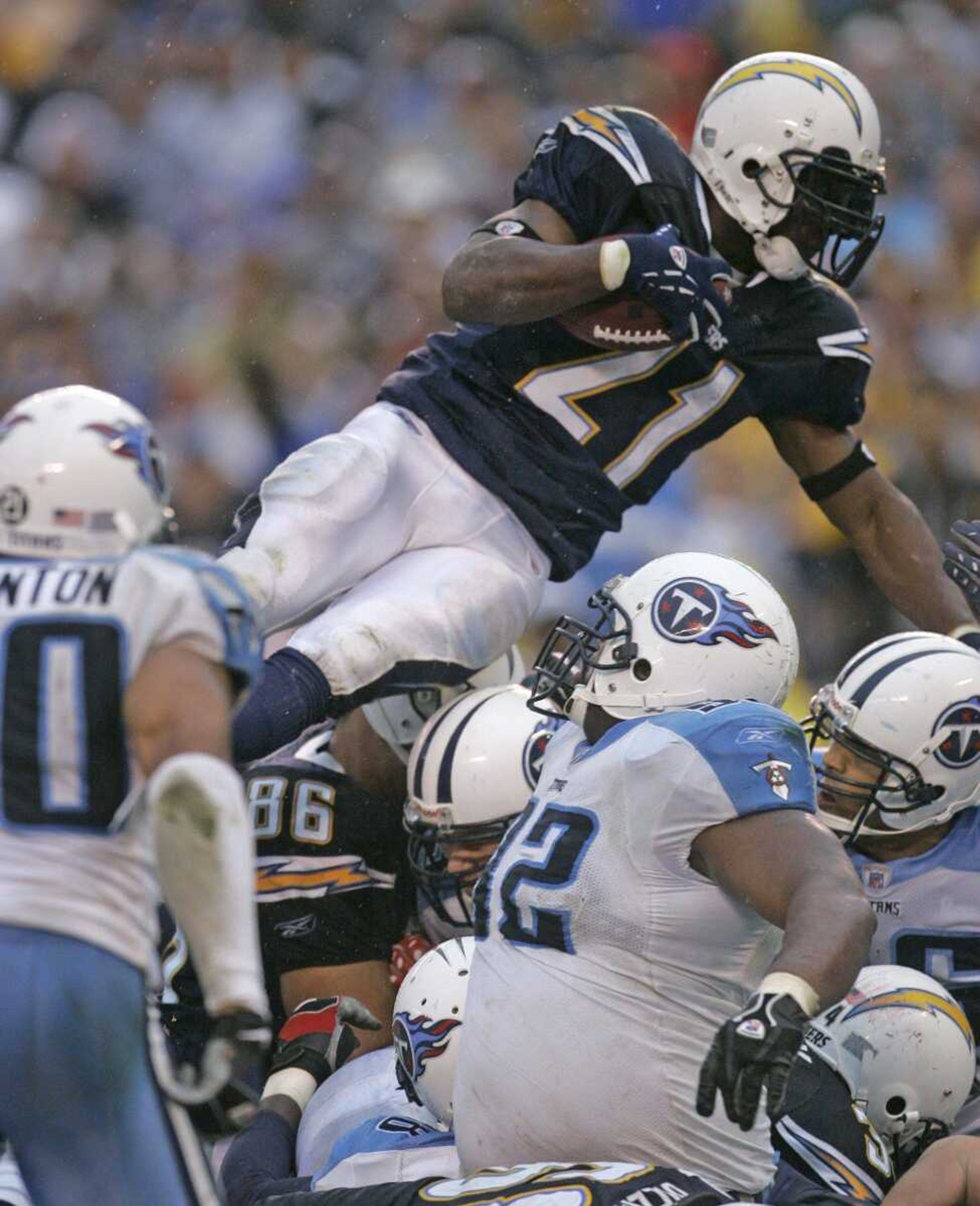 Chargers running back LaDainian Tomlinson leaped over the top for a 1-yard touchdown during the fourth quarter of the Chargers' 17-6 victory against the Tennessee Titans in their wild-card playoff game Sunday in San Diego. (LENNY IGNELZI ~ Associated Press)