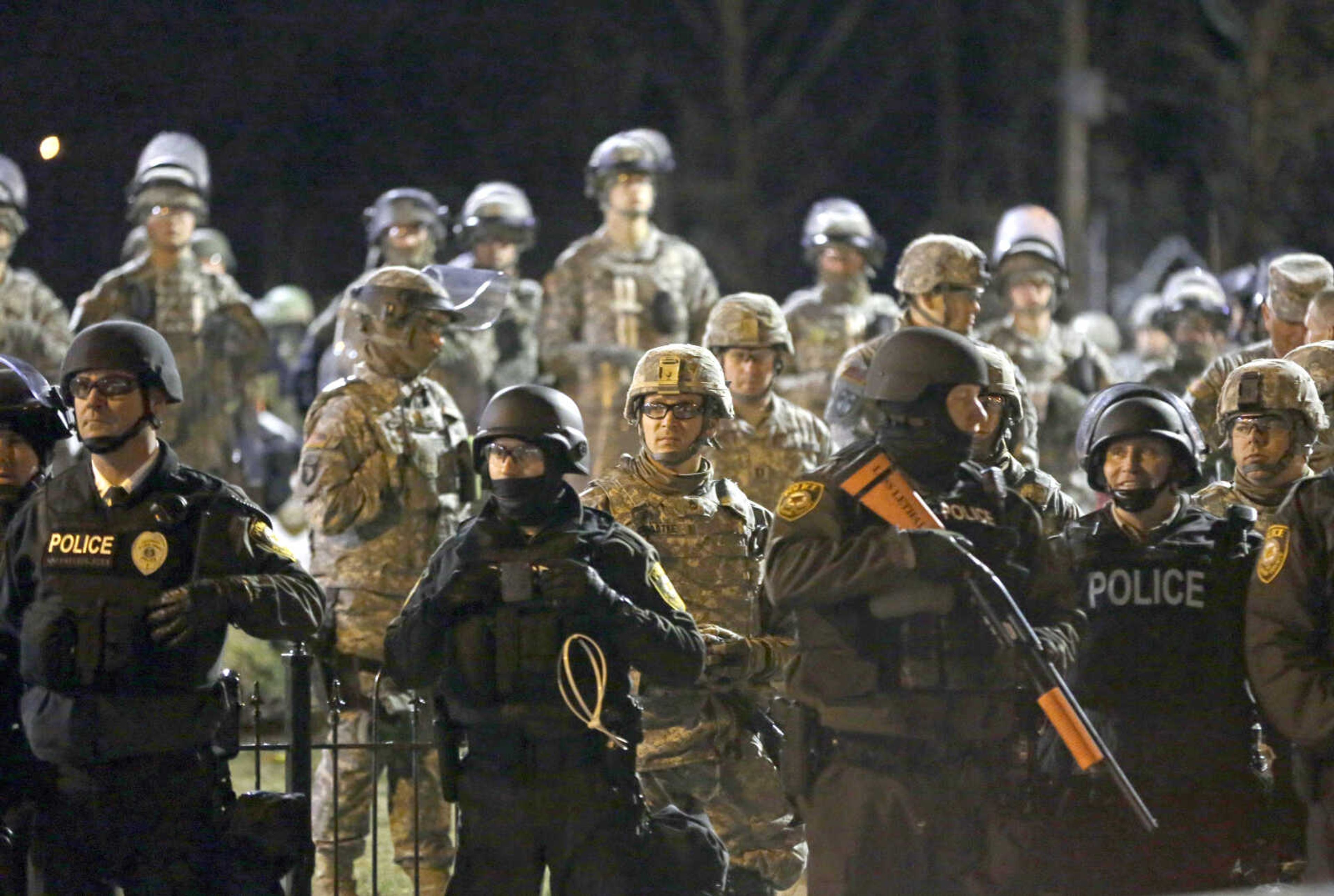 Police and Missouri National Guardsmen stand guard as protesters gather Nov. 28, 2014, in front of the Ferguson Police Department in Ferguson, Missouri.