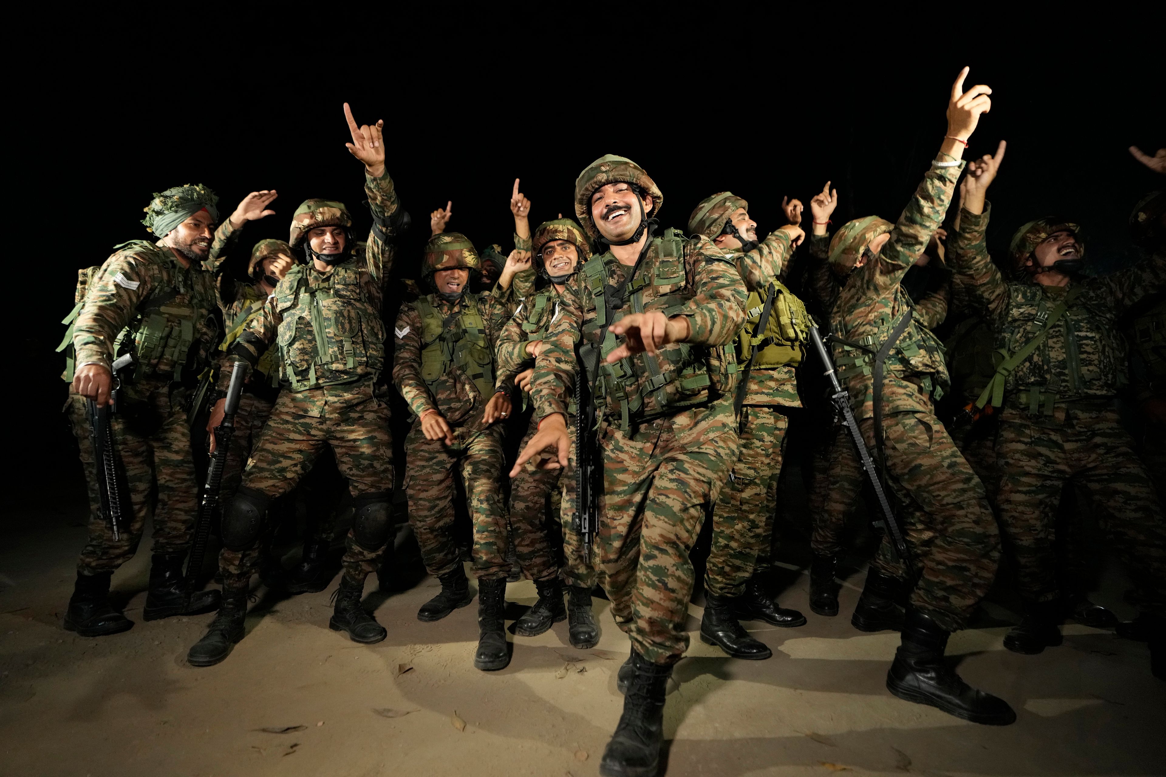 Indian army soldiers dance to celebrate Diwali, near Line of Control that divides Kashmir region between India and Pakistan, in Akhnoor sector, about 66 kilometers (41 miles) from Jammu, India, Monday, Oct. 28, 2024. (AP Photo/Channi Anand)