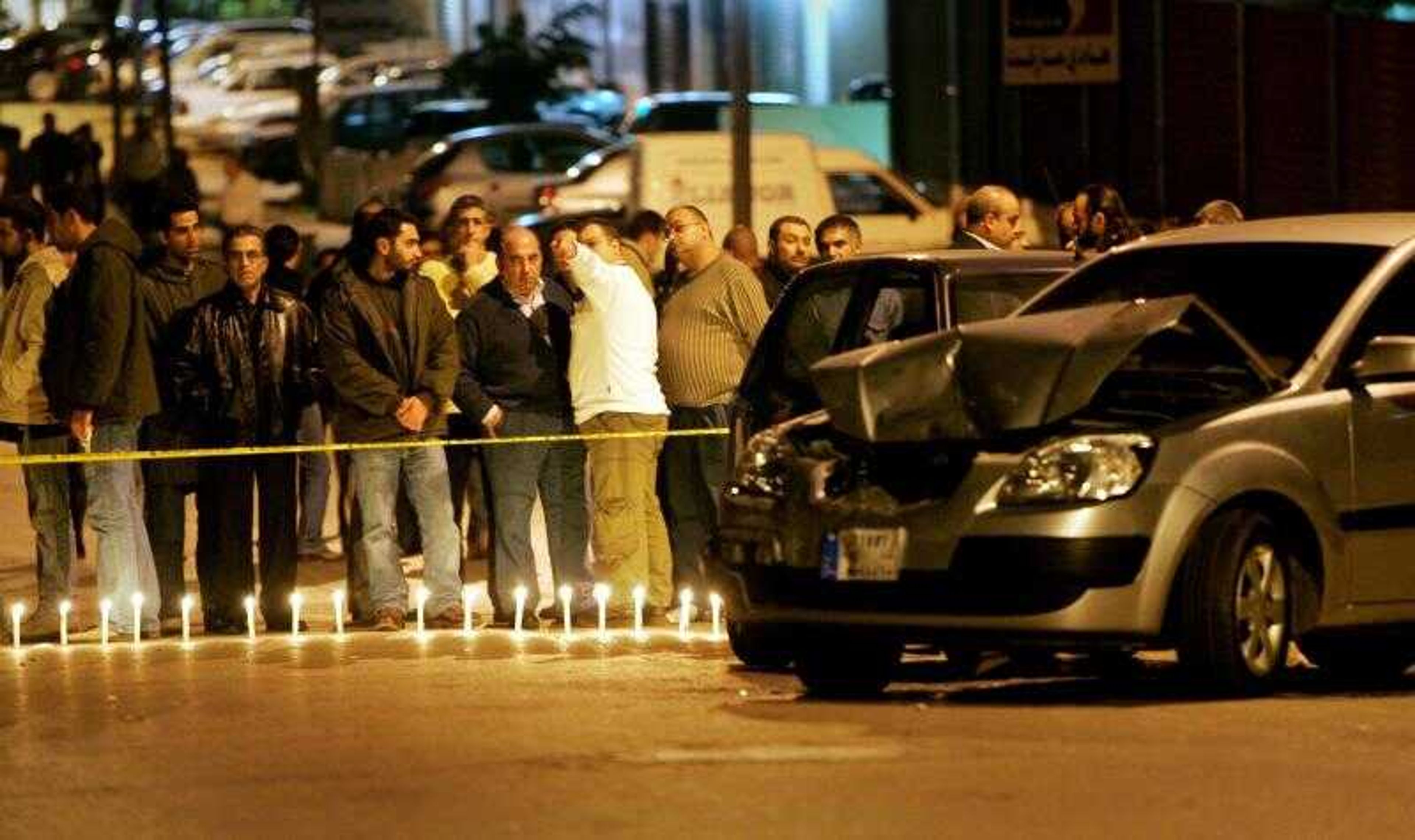 Mourners observed the scene by a line of candles placed under the line of crime-scene tape at a vigil held Tuesday at the scene where anti-Syrian Christian politician Pierre Gemayel was assassinated in Beirut, Lebanon. (BEN CURTIS ~ Associated Press)