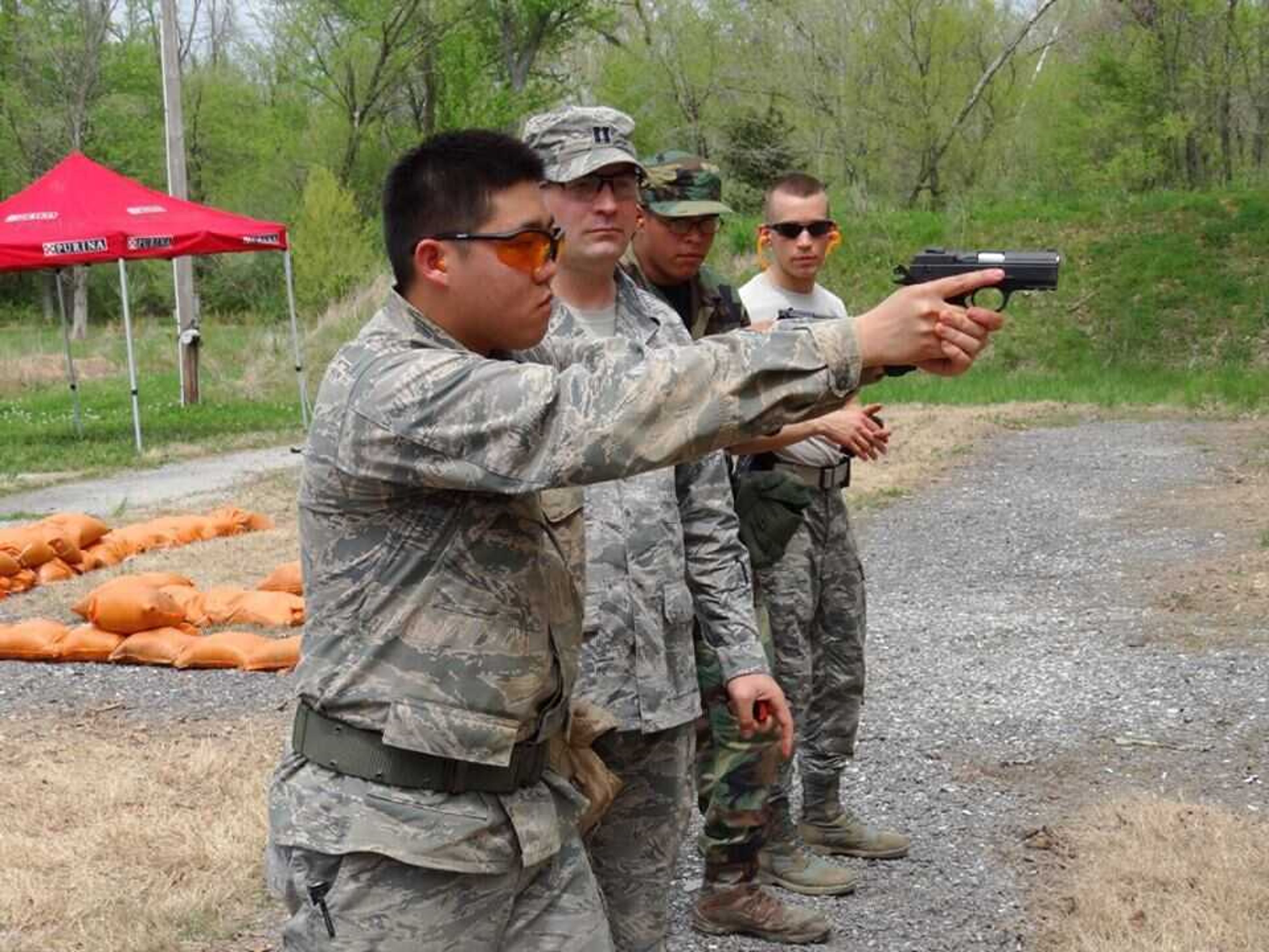 This photo is of Captain Holt and Captain Landon giving firearm instruction to Cadets Wong and Estrada at the shooting range.