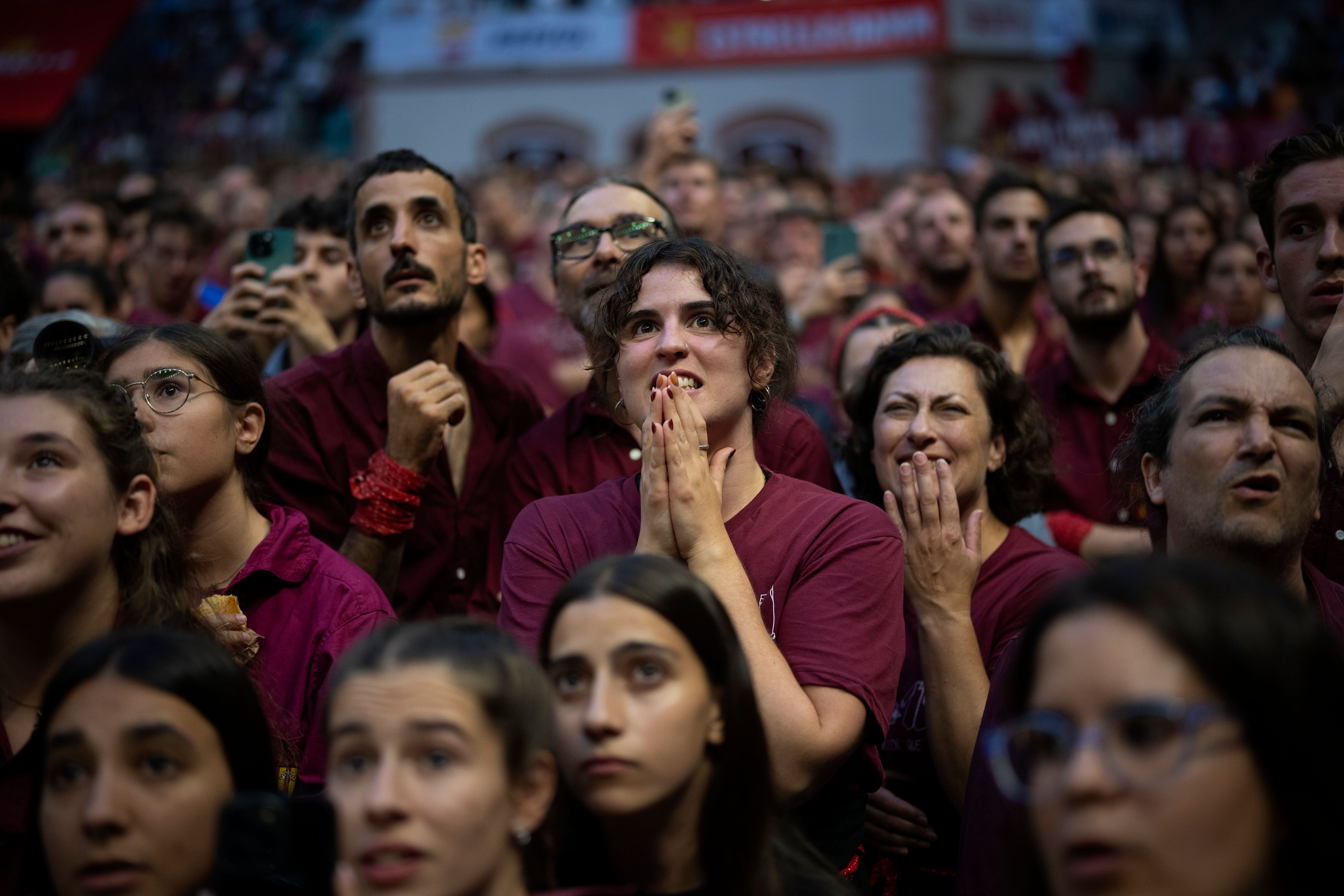 Assistants look as members of a "Castellers" form a human tower, during the 29th Human Tower Competition in Tarragona, Spain, Saturday, Oct. 5, 2024. (AP Photo/Emilio Morenatti)