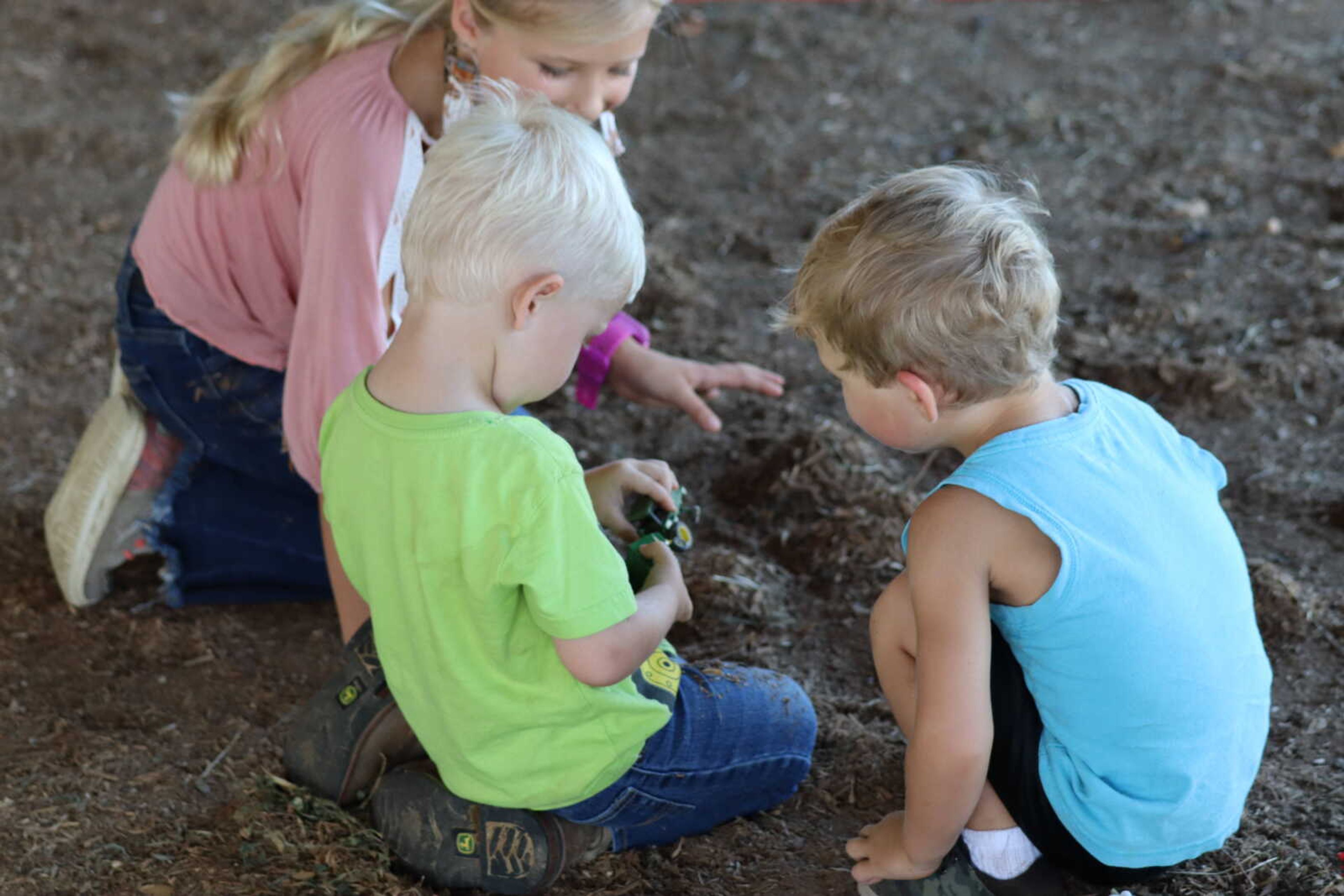 Children play in the dirt with toy trucks while SEMO Prospect Show continues on Saturday.