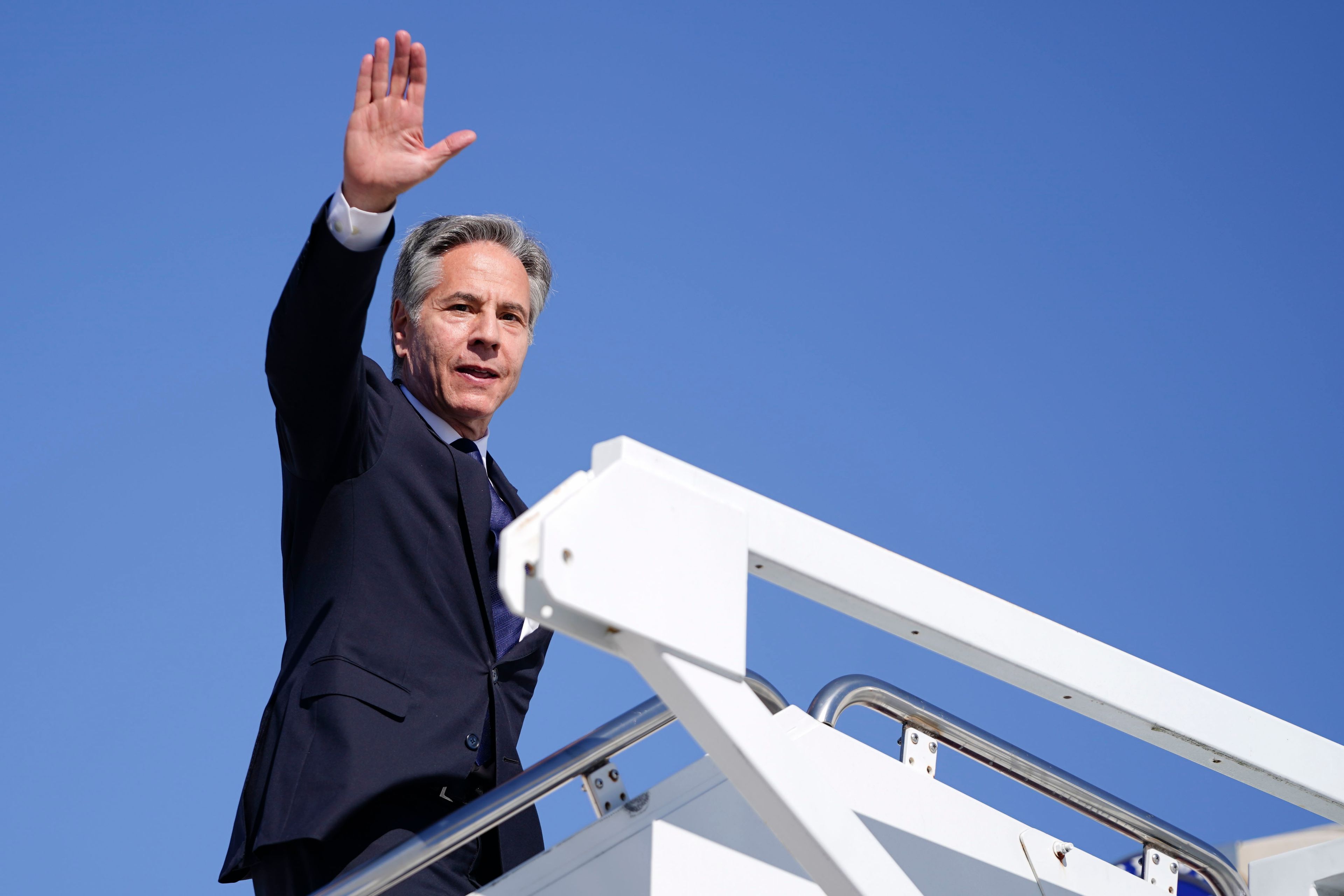 Secretary of State Antony Blinken waves as he boards a plane en route to the Middle East as he departs Joint Base Andrews, Md., Monday, Oct. 21, 2024. (Nathan Howard/Pool Photo via AP)