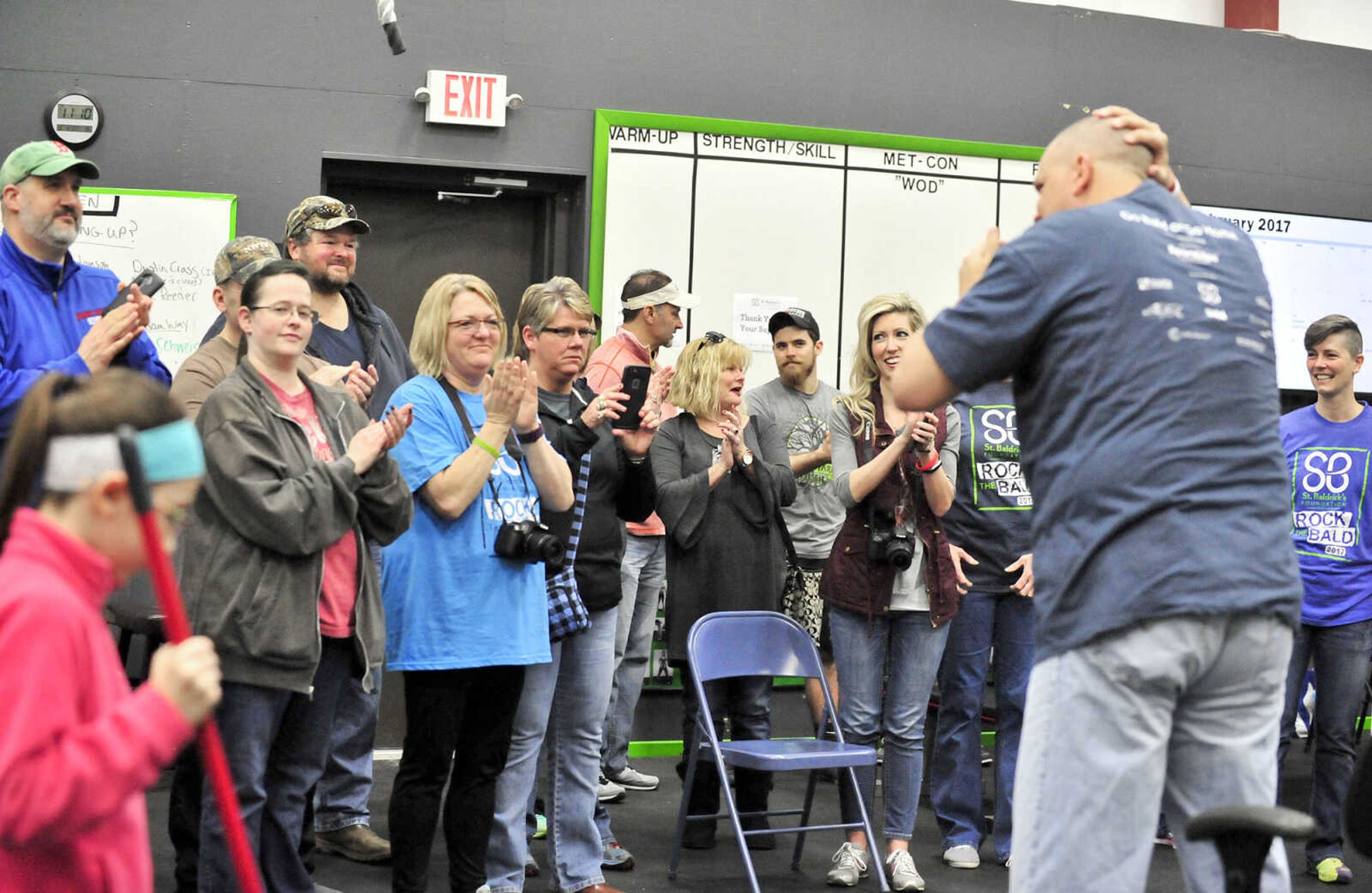 The crowd cheers as Jackson school superintendent John Link stands after getting his head shaved on Saturday, March 4, 2017, during the St. Baldrick's Foundation fundraiser at Old Orchard CrossFit in Jackson.