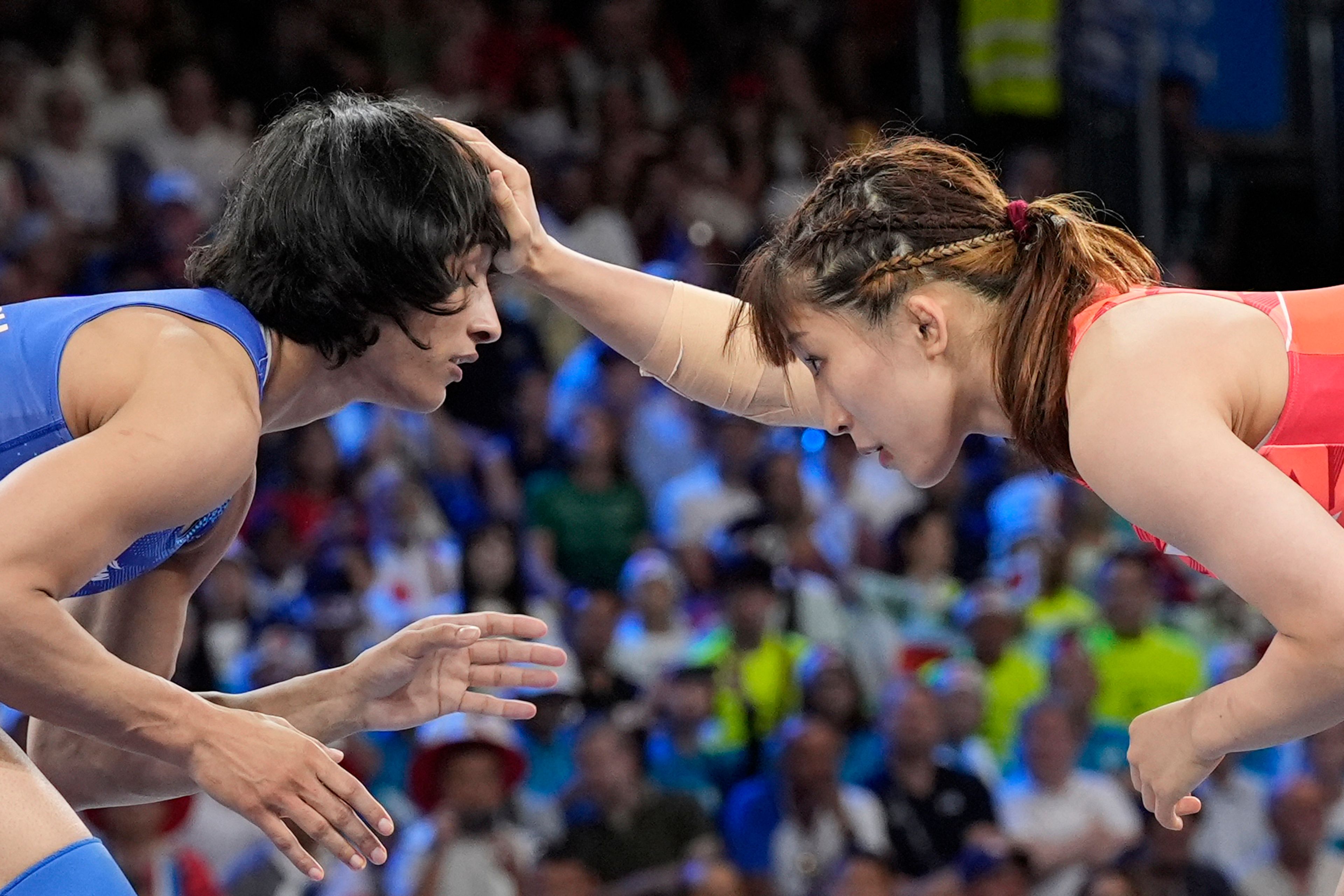 CORRECTS NAME TO VINESH PHOGAT, NOT VINESH VINESH - Japan's Yui Susaki and India's Vinesh Phogat, left, compete in the round of 16 of the women's freestyle 50kg wrestling match, at Champ-de-Mars Arena, during the 2024 Summer Olympics, Tuesday, Aug. 6, 2024, in Paris, France. (AP Photo/Eugene Hoshiko)