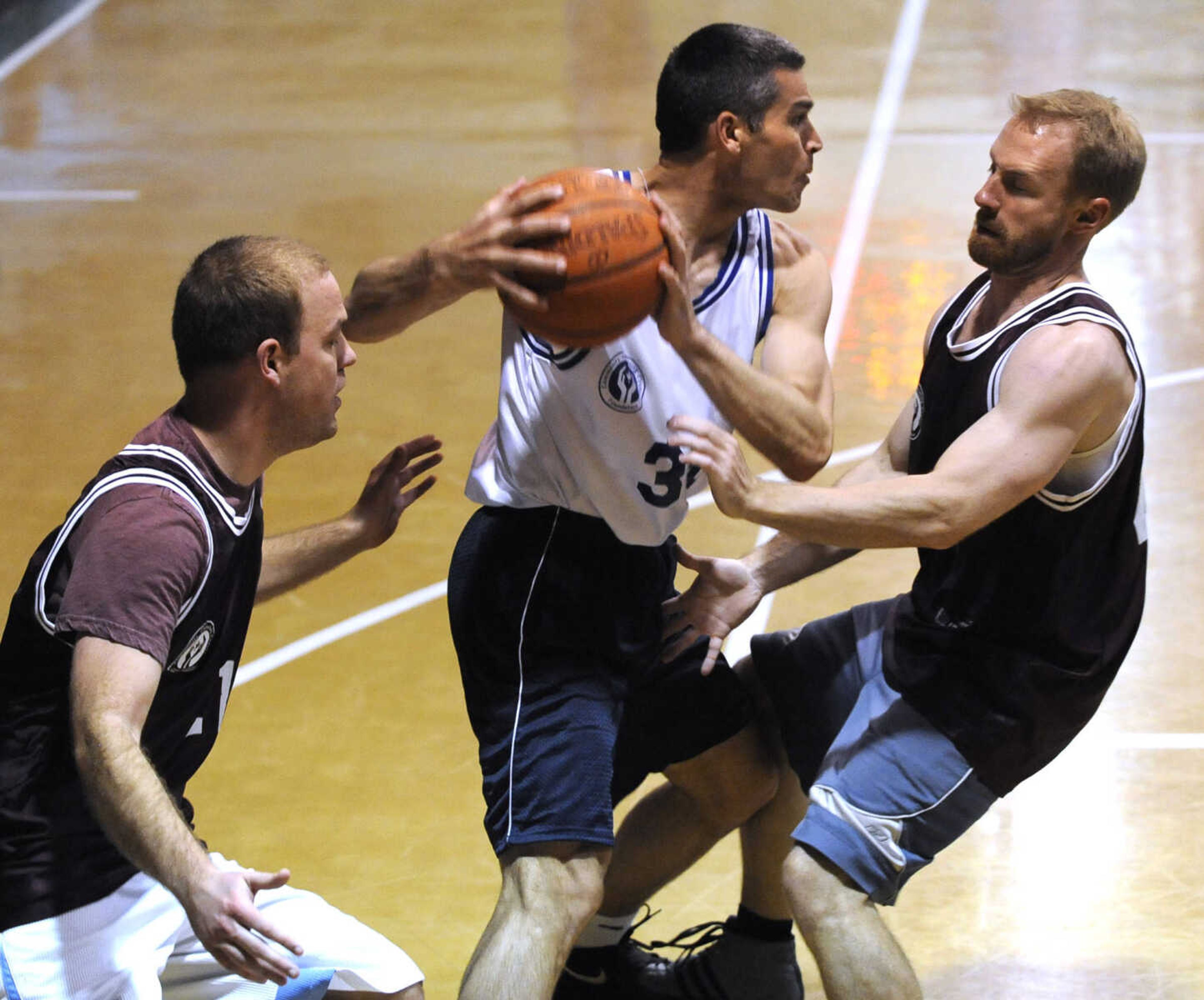 FRED LYNCH ~ flynch@semissourian.com
The Doctors' Alan "Cry Baby" Barnette looks to pass while guarded by the Lawyers' John "Johnny Tsunami" Steffens, left, and David "White Lightning" Wiegert during the Doctors vs. Lawyers Basketball Showdown on Saturday, March 22, 2014 at the DePaul Center in Cape Girardeau.