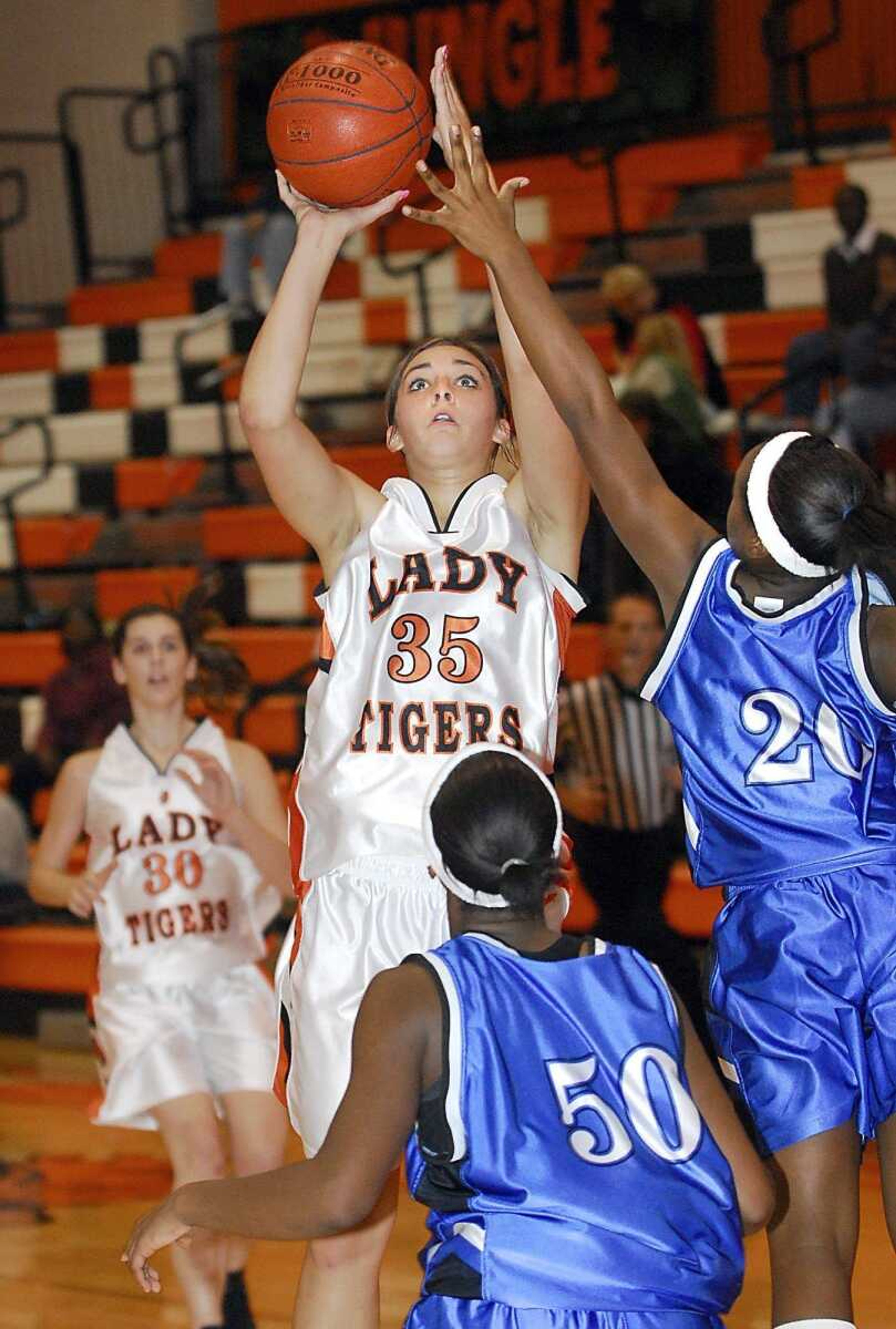 Central's Wendi Zickfield shot over Charleston's Tariah Simpson (50) and Chelsie Lane in the second quarter Monday night at Central High School. (Fred Lynch)