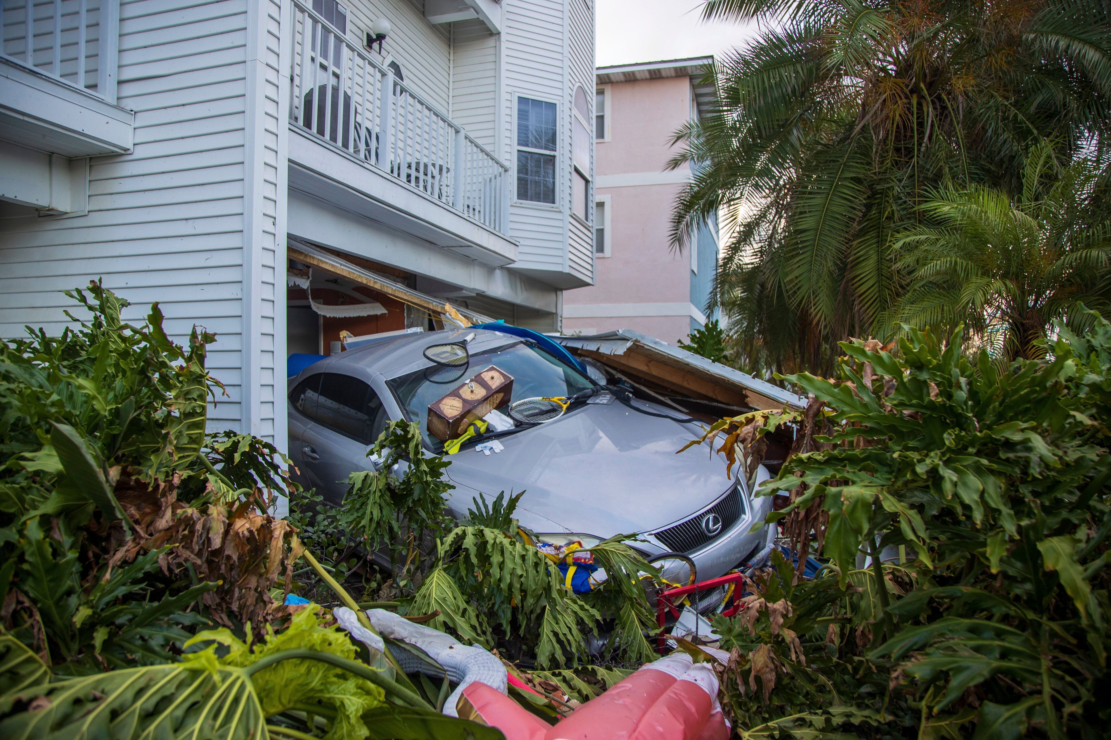 A vehicle sits outside of its garage after storm surge from Hurricane Helene, Saturday, Sept. 28, 2024, in Madeira Beach, Fla. (Luis Santana/Tampa Bay Times via AP)