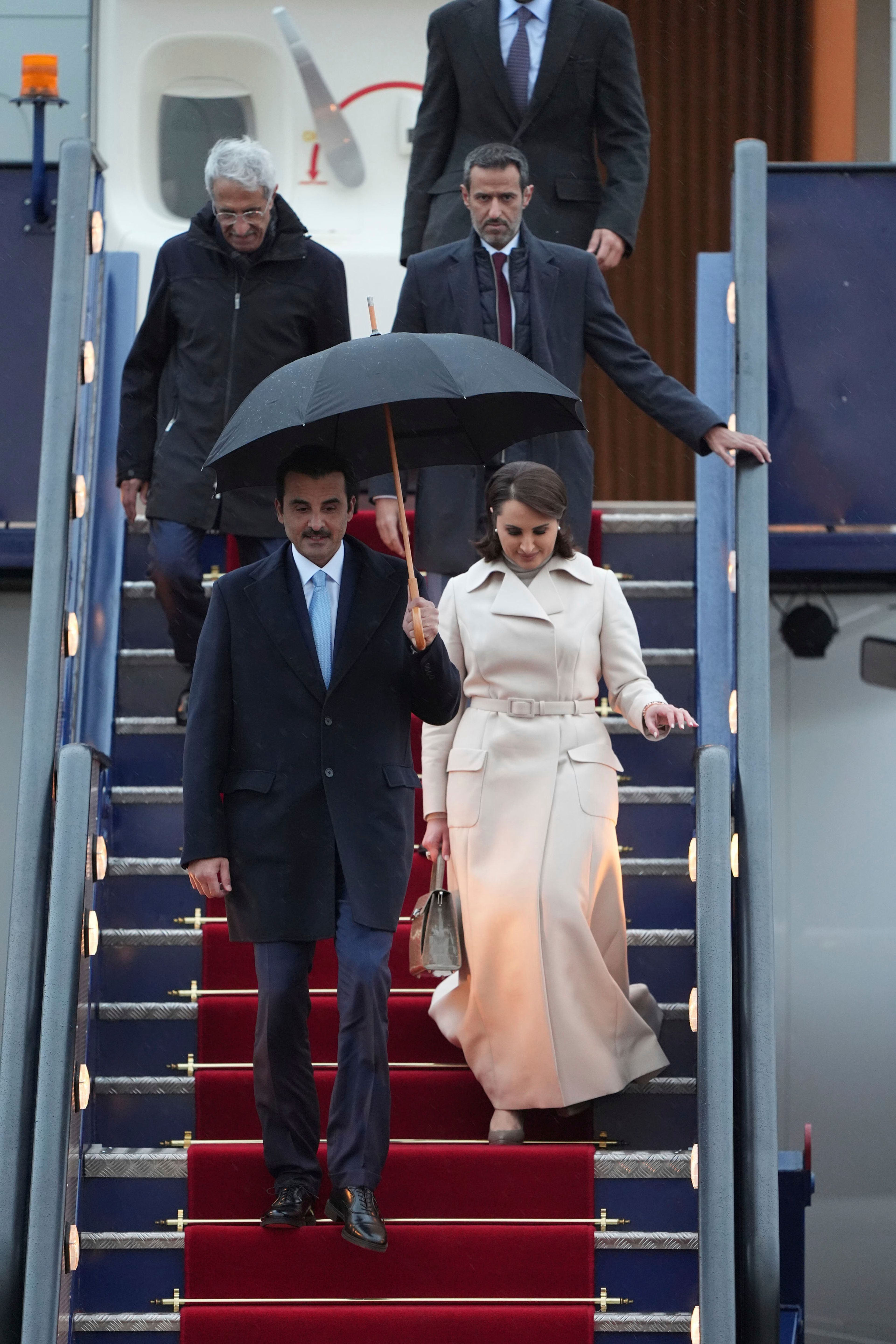 Emir of Qatar Sheikh Tamim bin Hamad bin Khalifa Al Thani, front left, and Sheikha Hind bint Hamad bin Khalifa al-Thani, front right, arrive at Stansted Airport in Essex, England, Monday Dec. 2, 2024, for a state visit hosted by King Charles III. ( Joe Giddens/PA via AP)