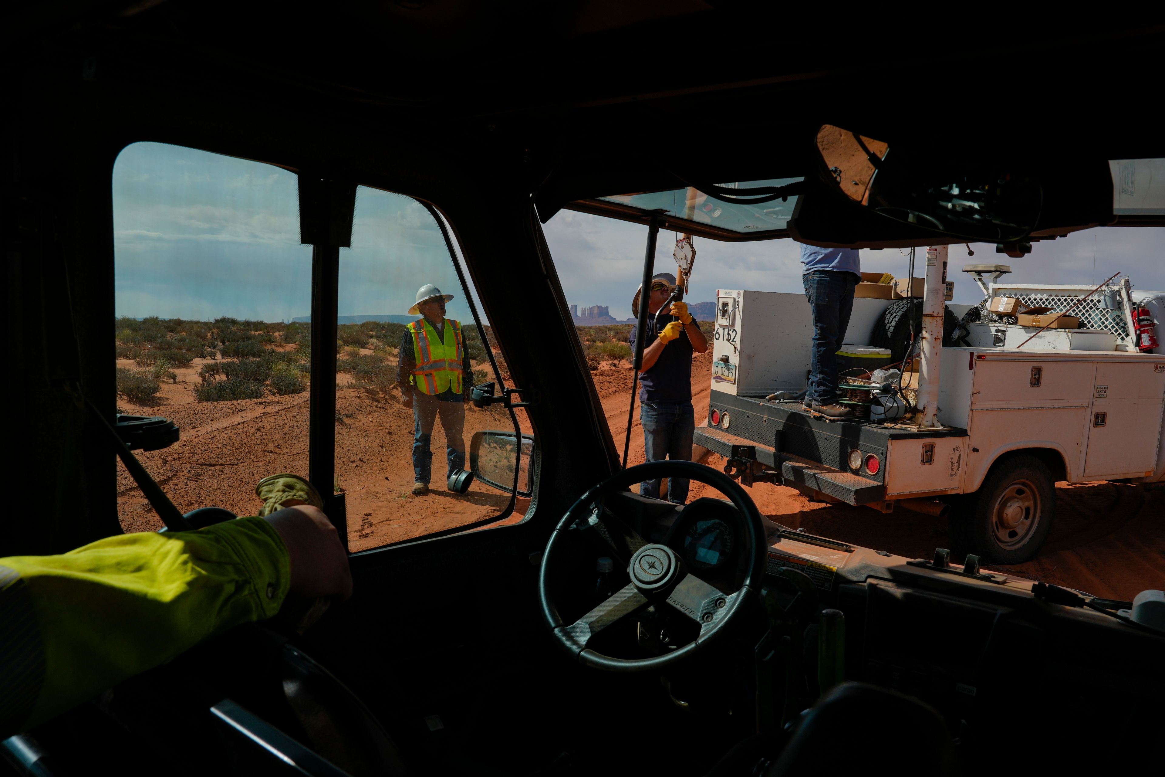 Robert Black, left, with the Navajo Tribal Utility Authority, supervises as a volunteer crew lifts a power line pole, Tuesday, Oct. 8, 2024, on the Navajo Nation in Halchita, Utah. (AP Photo/Joshua A. Bickel)