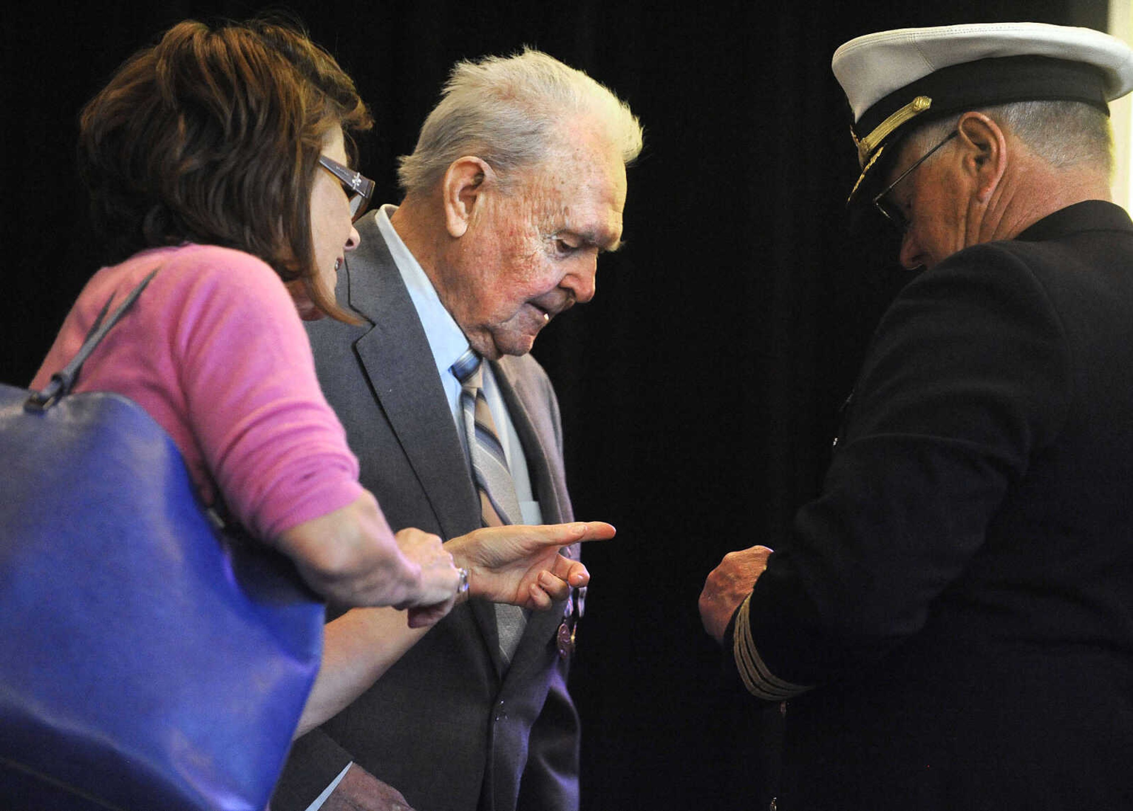 LAURA SIMON ~ lsimon@semissourian.com

Diane Gomersall, left, helps Sgt. Clifford Heinrich, center, and retired U.S. Navy Commander Lawson Burgfeld with Heinrich's medals on Monday, March 21, 2016, during the living history event honoring the WWII lost crew of the Flying Fortress 812, and the medal presentation to Sgt. Clifford Heinrich at Alma Schrader Elementary. Heinrich was presented with an American Campaign Medal, WWII Victory Medal, Army Good Conduct Medal, a WWII Lapel Button, European-African-Middle Eastern Campaign Medal and the Purple Heart for his service during WWII during Monday's presentation.