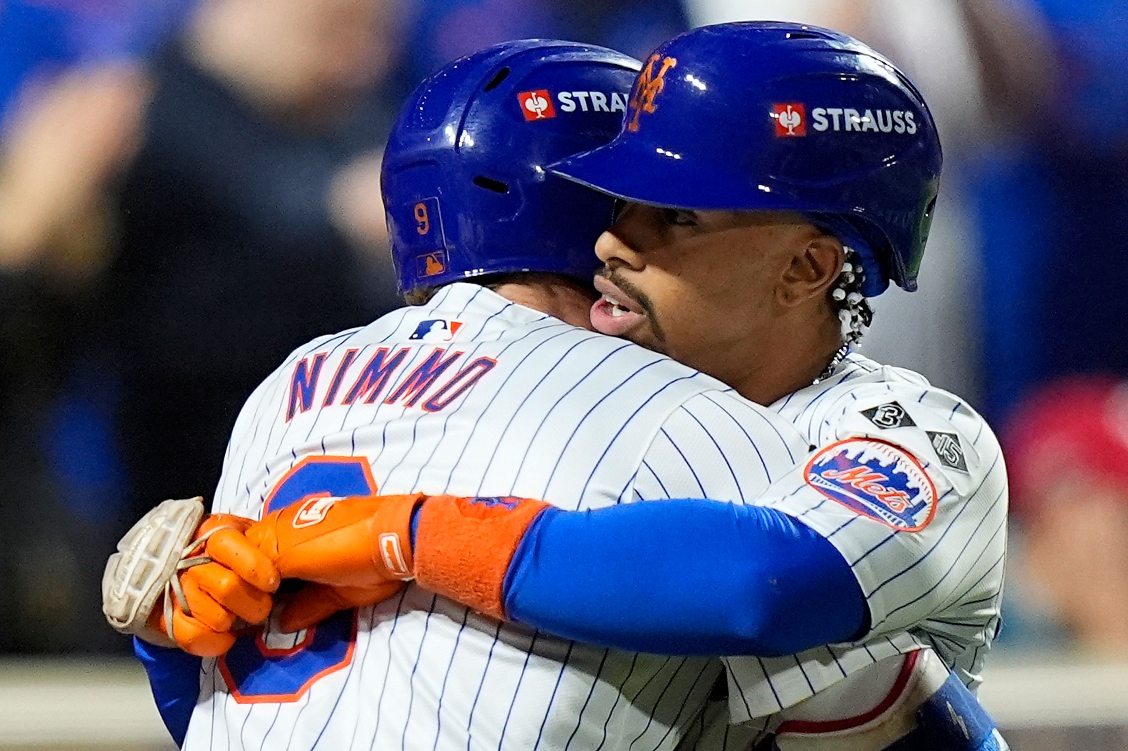 New York Mets Brandon Nimmo (9) hugs Francisco Lindor (12) after Lindor hit a grand slam home run against the Philadelphia Phillies during the sixth inning of Game 4 of the National League baseball playoff series, Wednesday, Oct. 9, 2024, in New York. (AP Photo/Frank Franklin II)