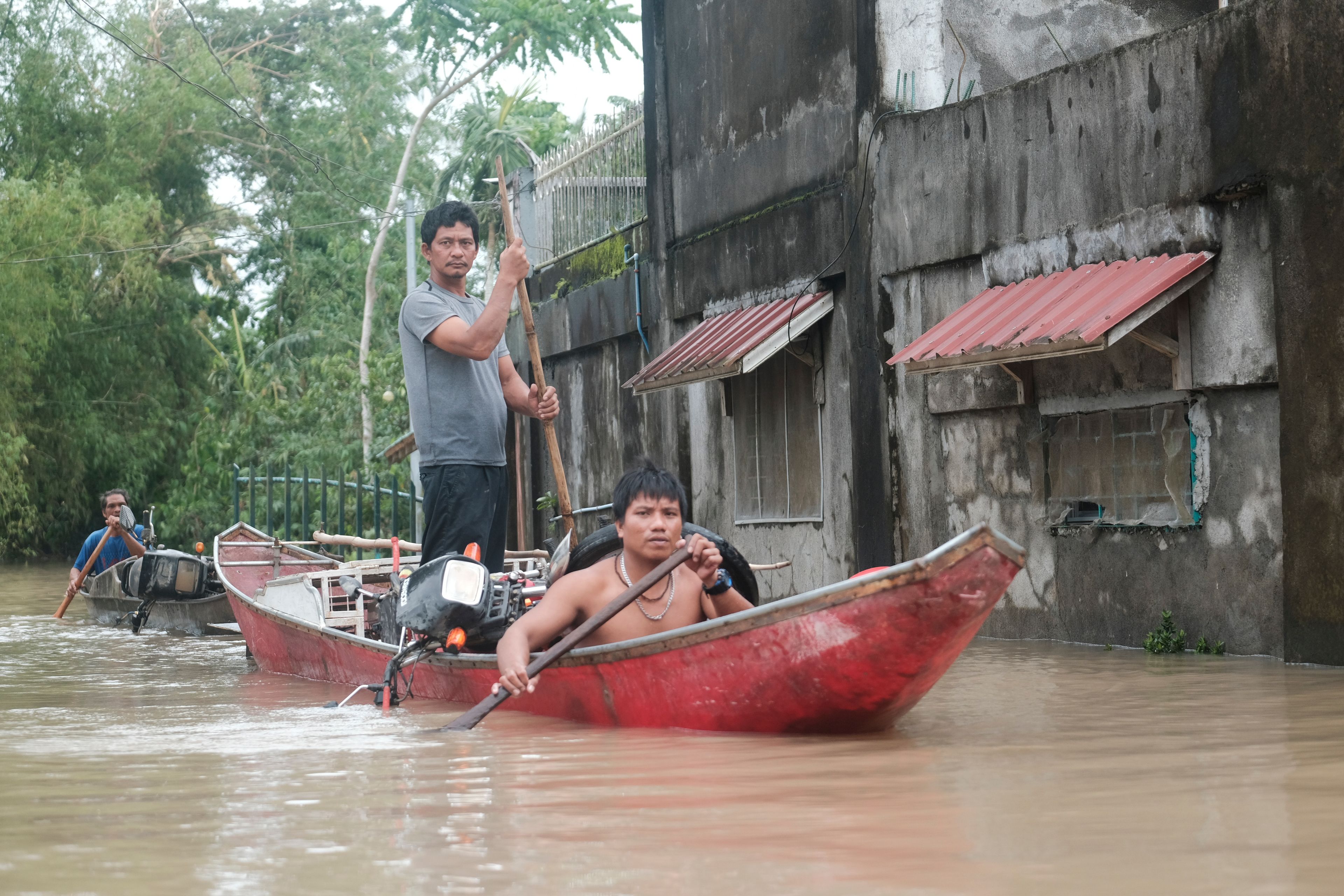 Residents use a boat to recover items from their flooded homes caused by Tropical Storm Trami, locally named Kristine, as it continues to inundate Libon town, Albay province, Philippines on Thursday Oct. 24, 2024. (AP Photo/John Michael Magdasoc)