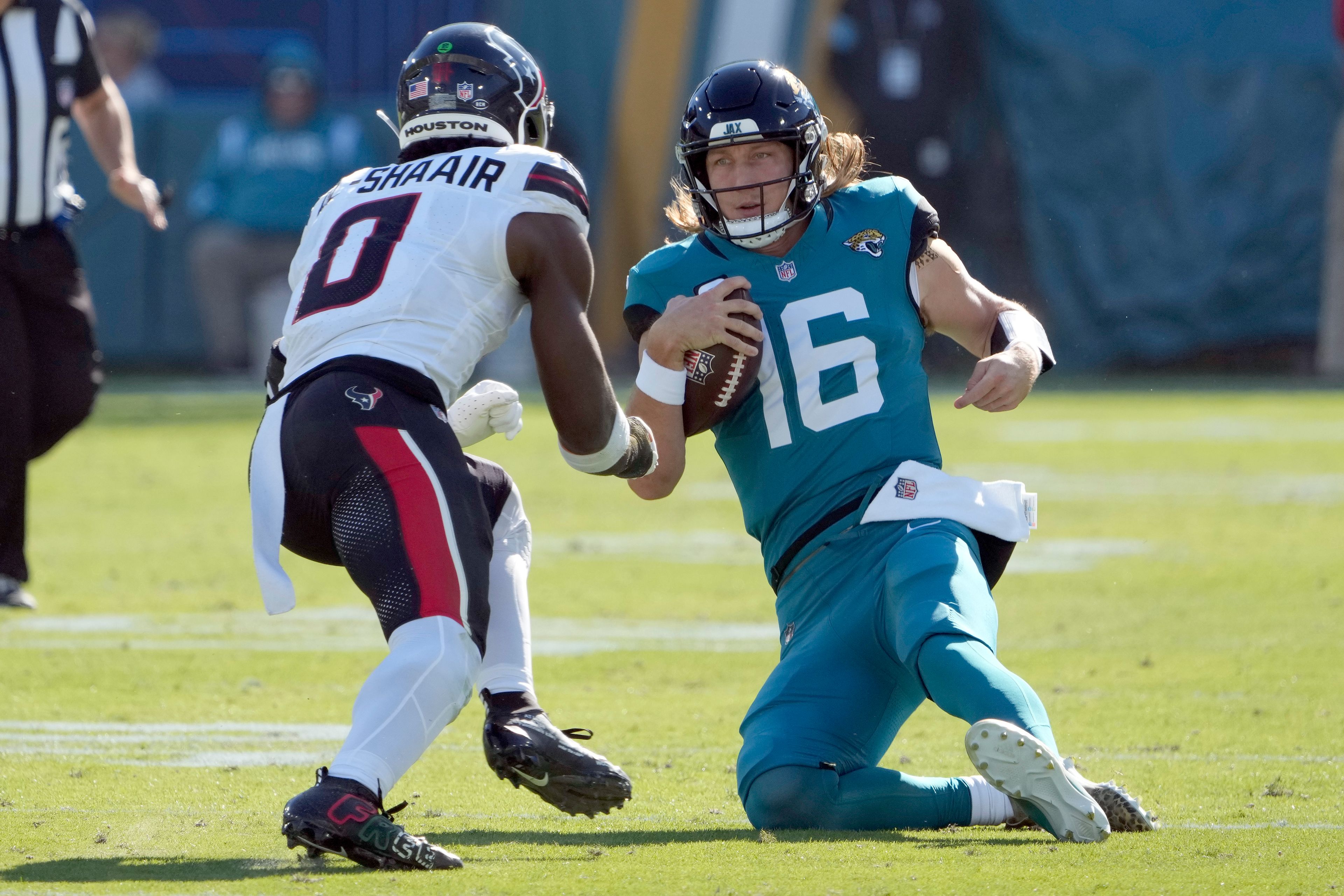 Jacksonville Jaguars quarterback Trevor Lawrence (16) slides in front of Houston Texans linebacker Azeez Al-Shaair (0) during the first half of an NFL football game Sunday, Dec. 1, 2024, in Jacksonville, Fla. Lawrence was injured on the play. (AP Photo/John Raoux)