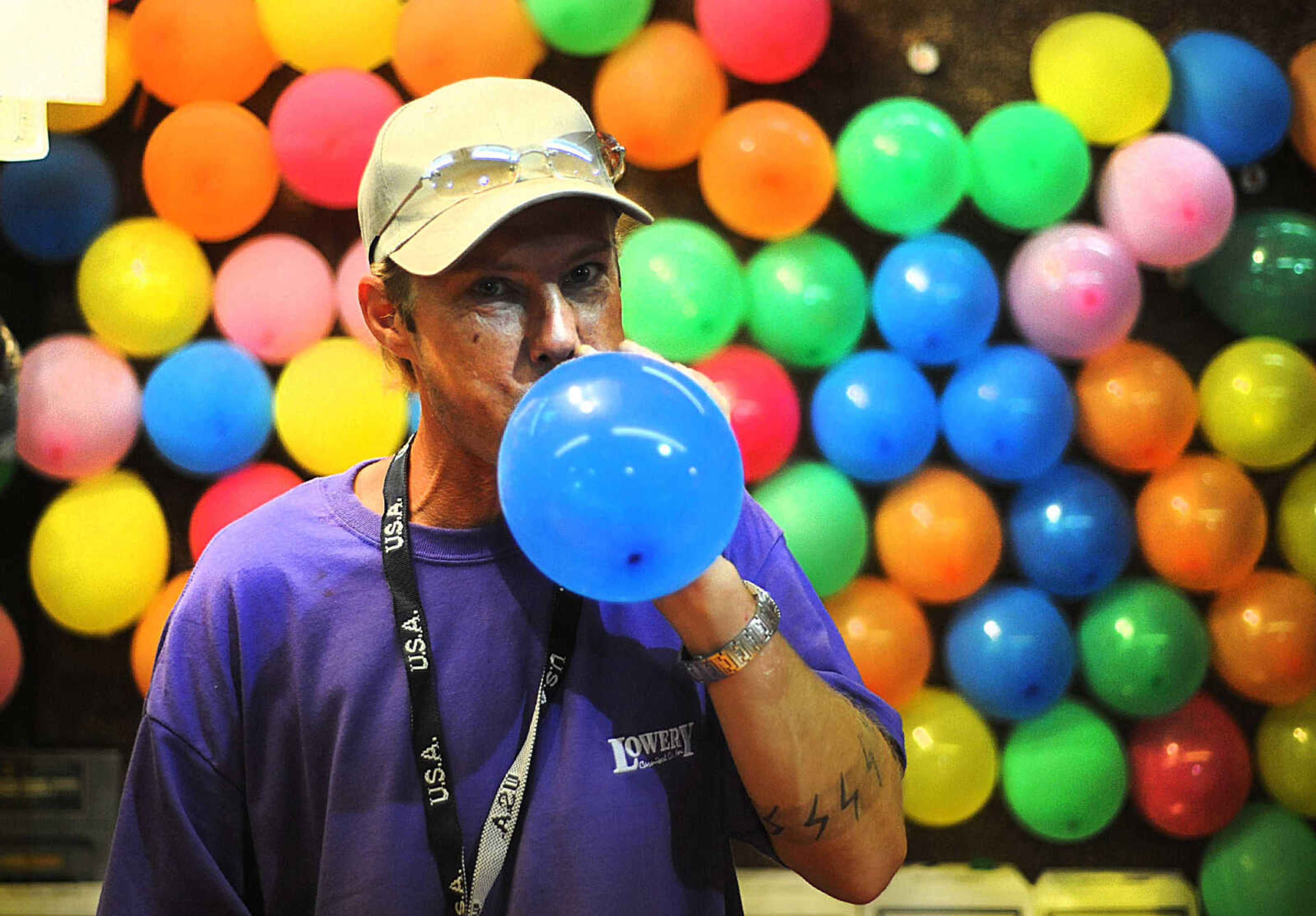 LAURA SIMON ~ lsimon@semissourian.com

John Elst blows up balloons to replace popped ones at the Bust-1-U-Win game at the SEMO District Fair, Wednesday, Sept. 10, 2014.