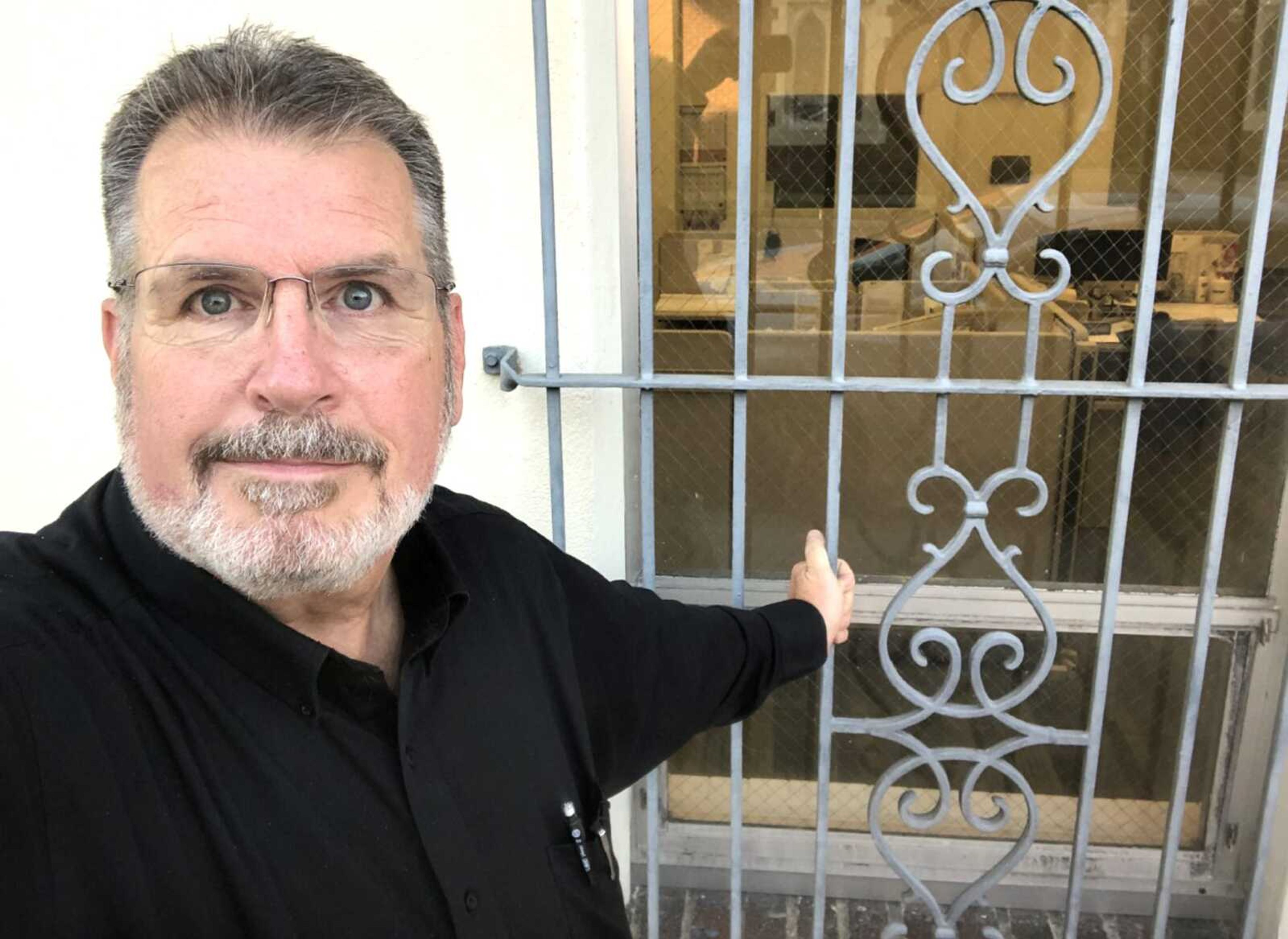 Retiring Southeast Missourian business editor Jay Wolz at the window where, as a child, he watched newspapers roll off the Missourian press. Now, instead of a printing press, Wolz can see his newsroom desk through the window.