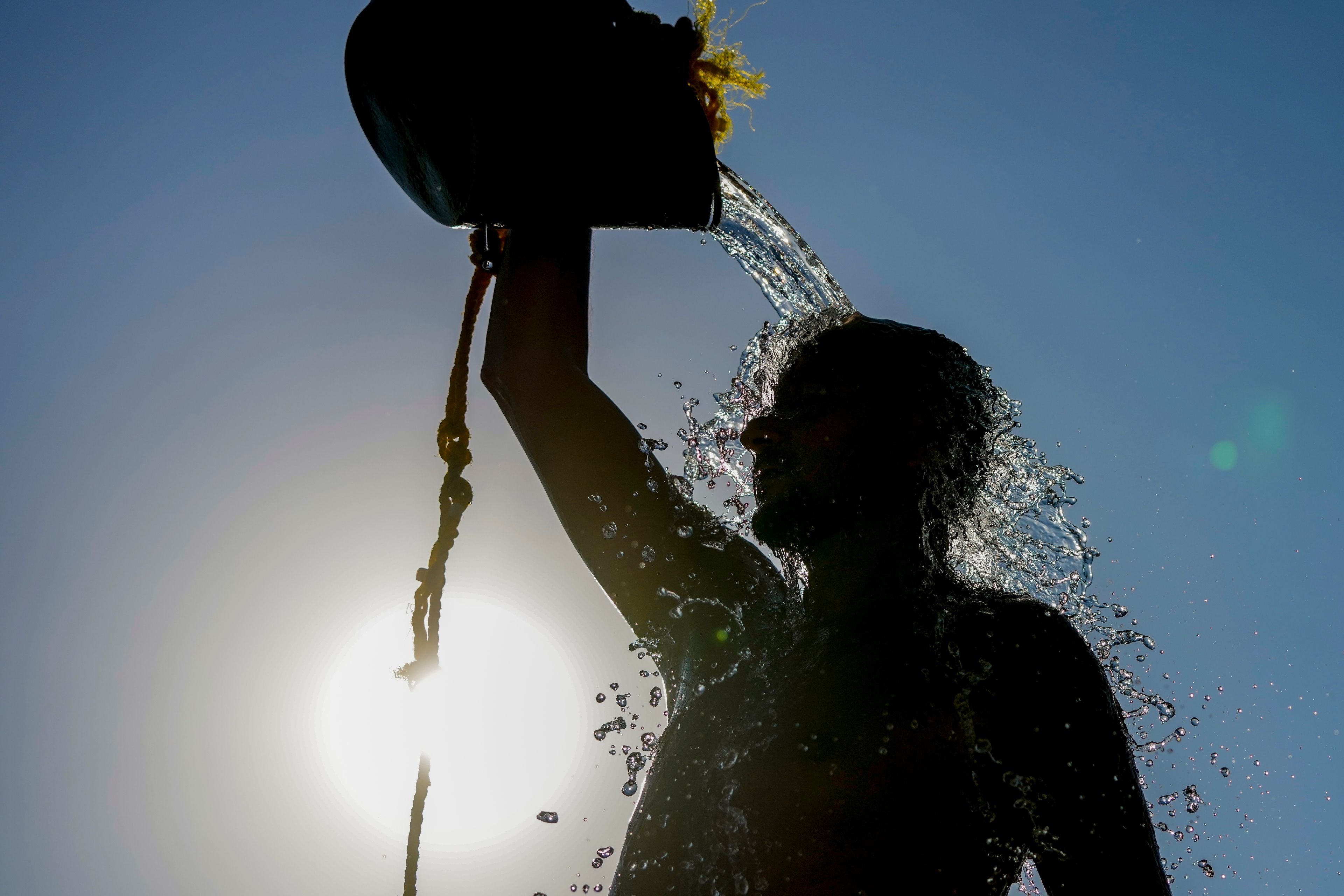 FILE - A man rinses with fresh water after playing beach volleyball on a hot day, at the Ramlet al-Baida public beach in Beirut, Lebanon, July 16, 2024. (AP Photo/Hassan Ammar, File)