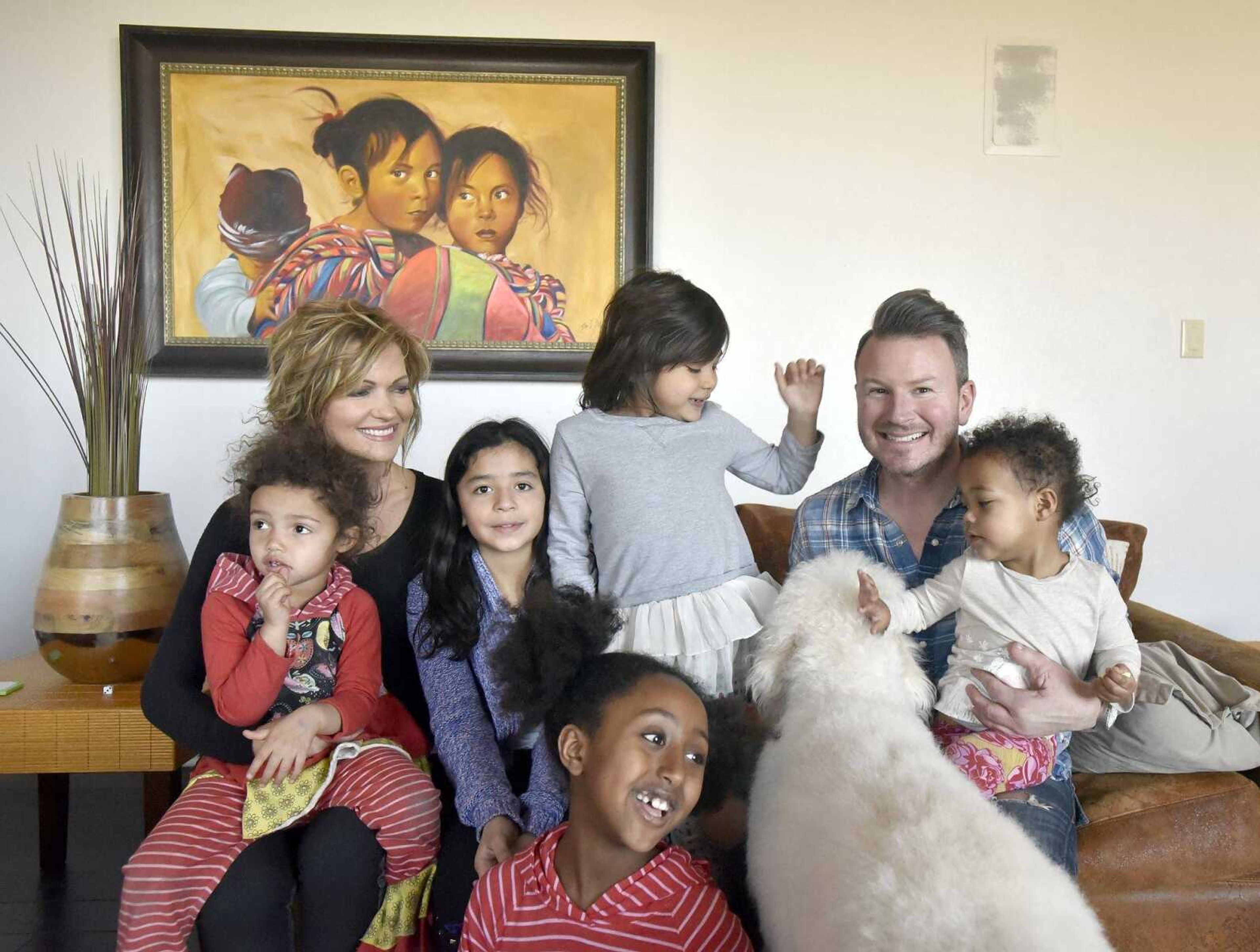 Pictured from left to right, Dolly, 3, Chantelle, Bianca, 10, Solie, 8, Ari, 5, Eric and Lennyx Becking, 1, group together for a family photo with their dog Marley on Saturday, Jan. 28, 2017, at the Becking's Cape Girardeau home.