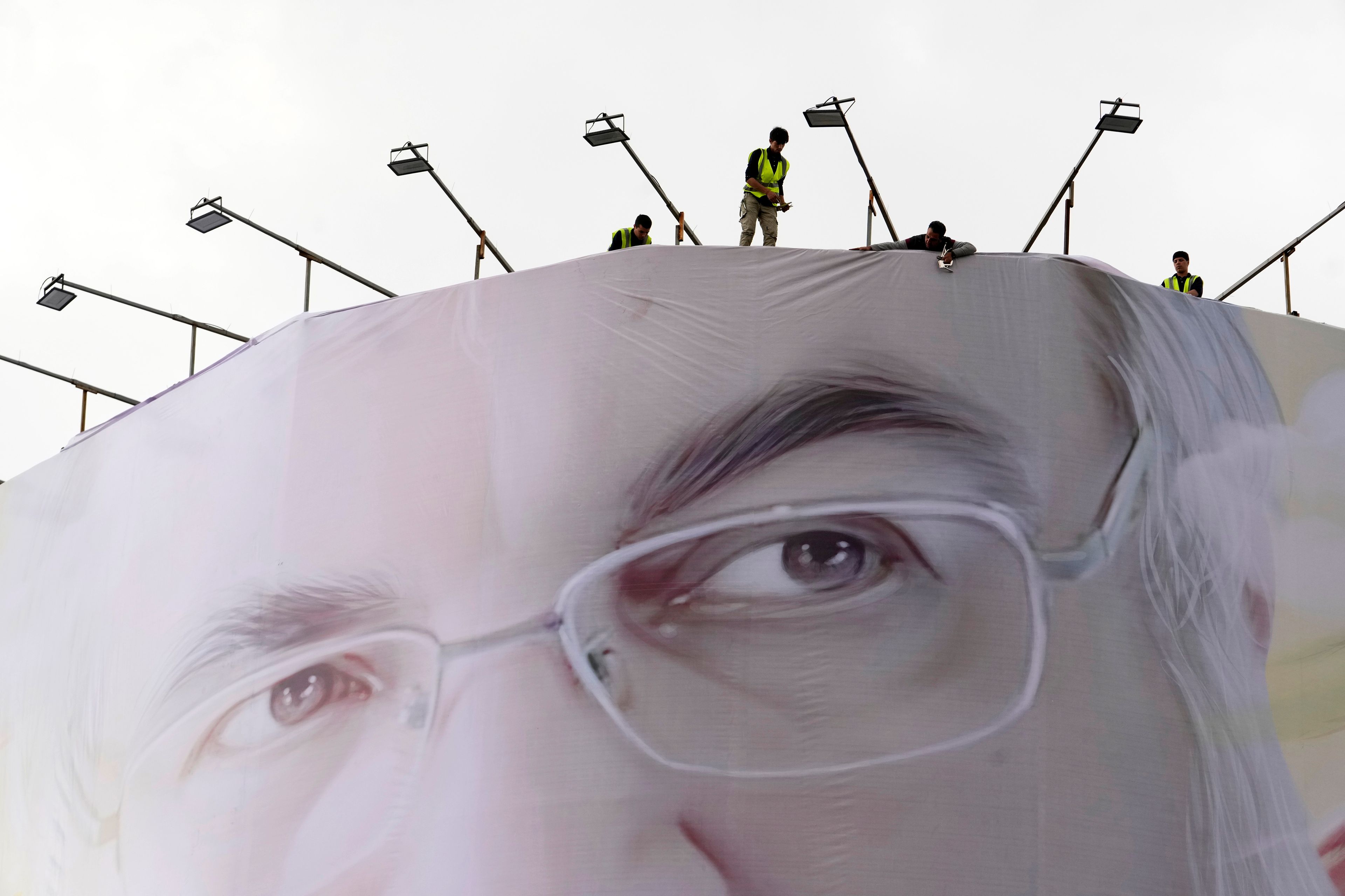 Workers install a huge portrait of slain Hezbollah leader Hassan Nasrallah on a building at Enqelab-e-Eslami (Islamic Revolution) Sq. in Tehran, Iran, Sunday, Sept. 29, 2024. (AP Photo/Vahid Salemi)