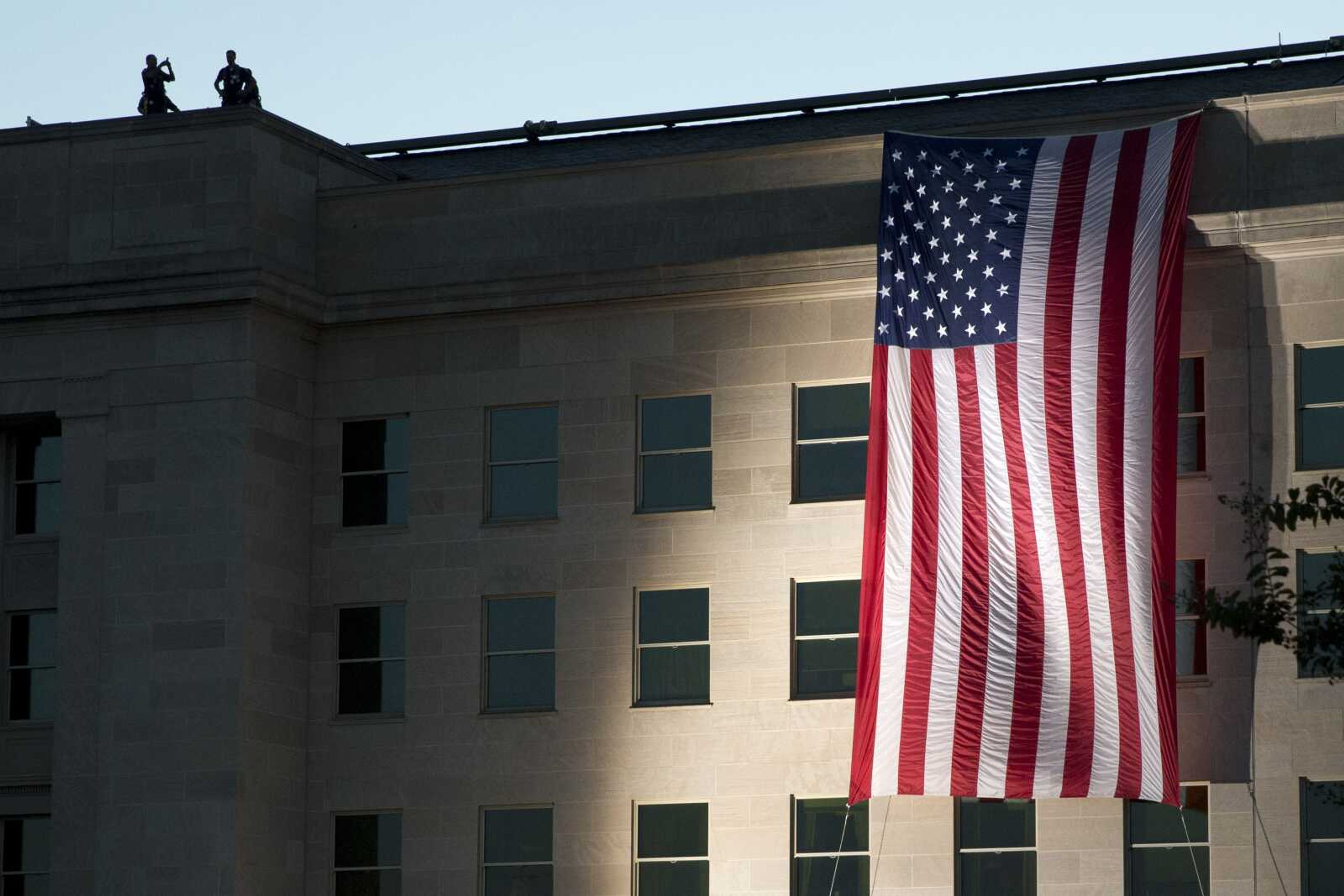 An American flag is draped on the side of the Pentagon where the building was attacked Sept. 11, 2001, on the 14th anniversary of the attack Sept. 11, 2015.