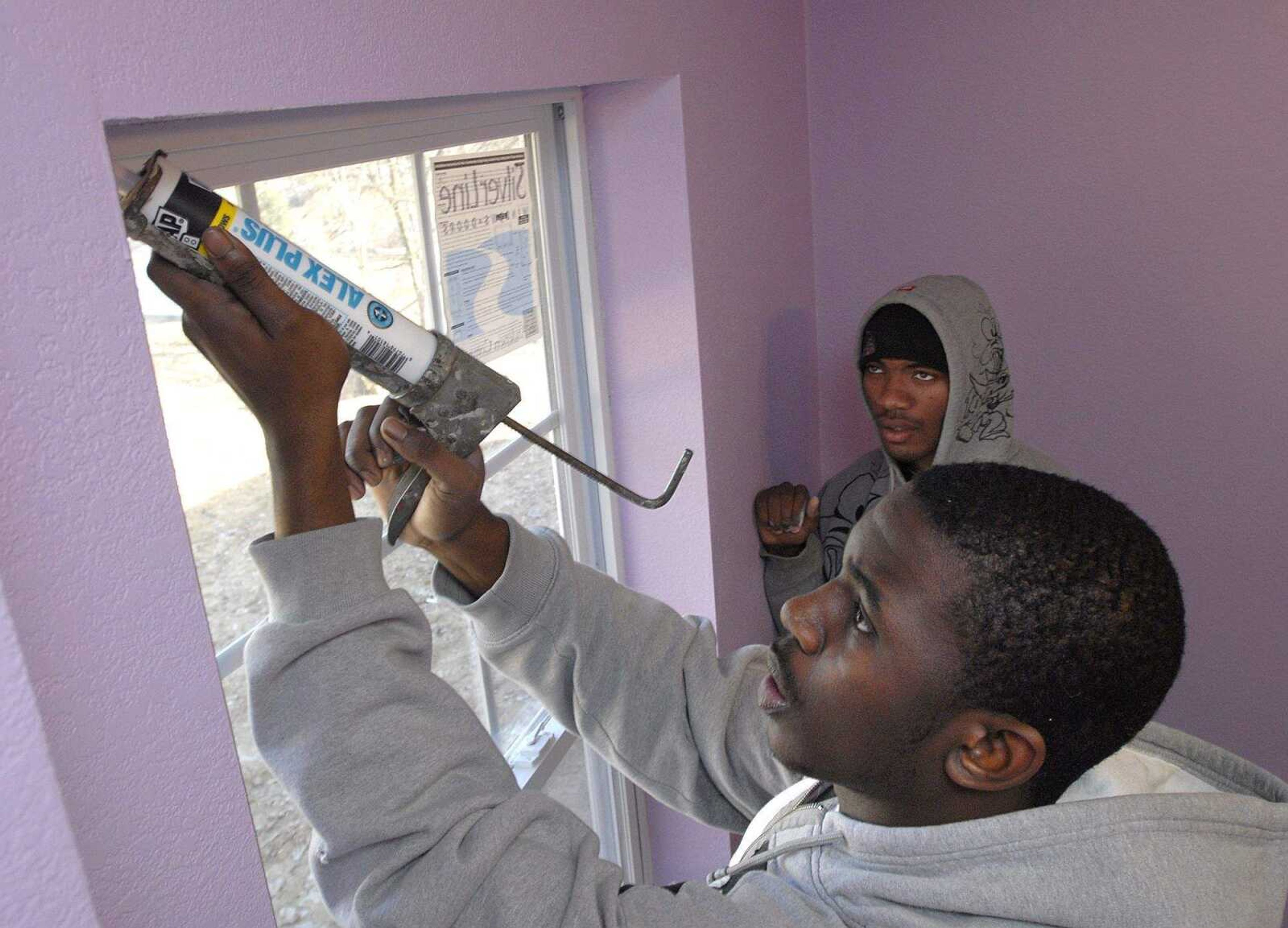 FRED LYNCH ~ flynch@semissourian.com
Mickey Tillmon caulks around a window with Brandon Steward at a Habitat for Humanity house Saturday in Cape Girardeau.