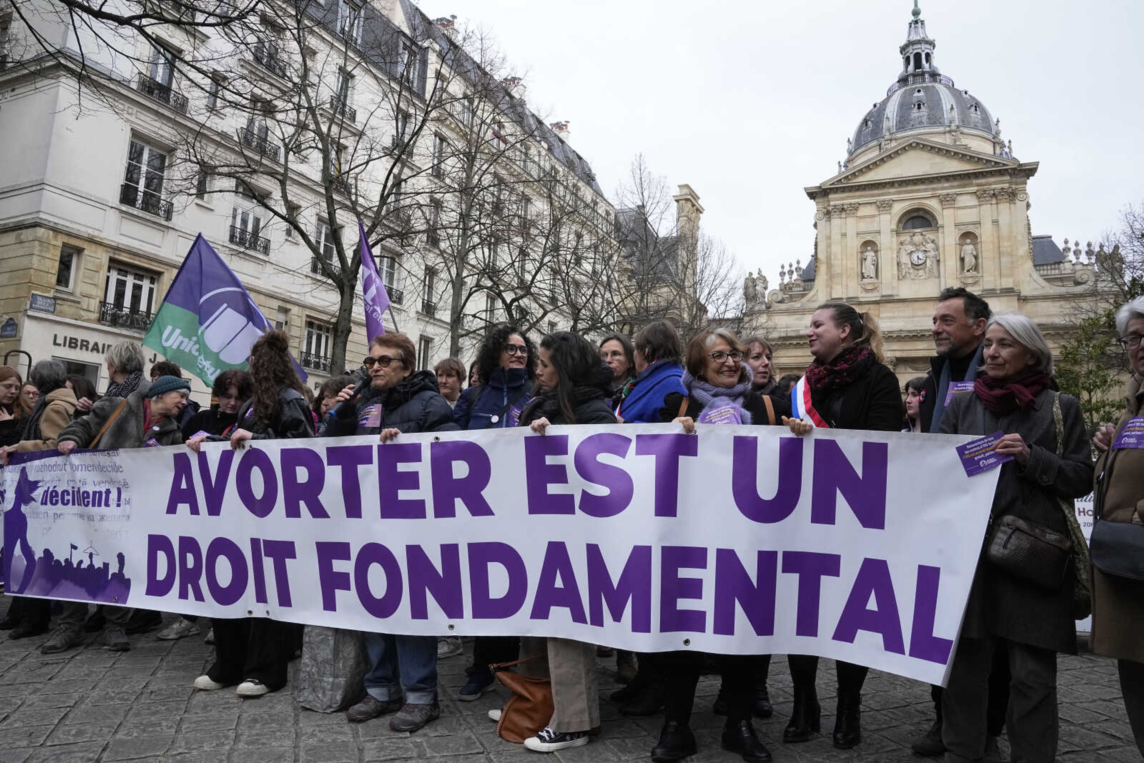 Pro-abortion rights activists hold banner reads  abortion is a fundamental right  during a rally for abortion rights outside La Sorbonne university in Paris, Wednesday Feb. 28, 2024. France's Senate is voting on a bill meant to enshrine a woman's right to an abortion in the French Constitution. (AP Photo/Michel Euler)