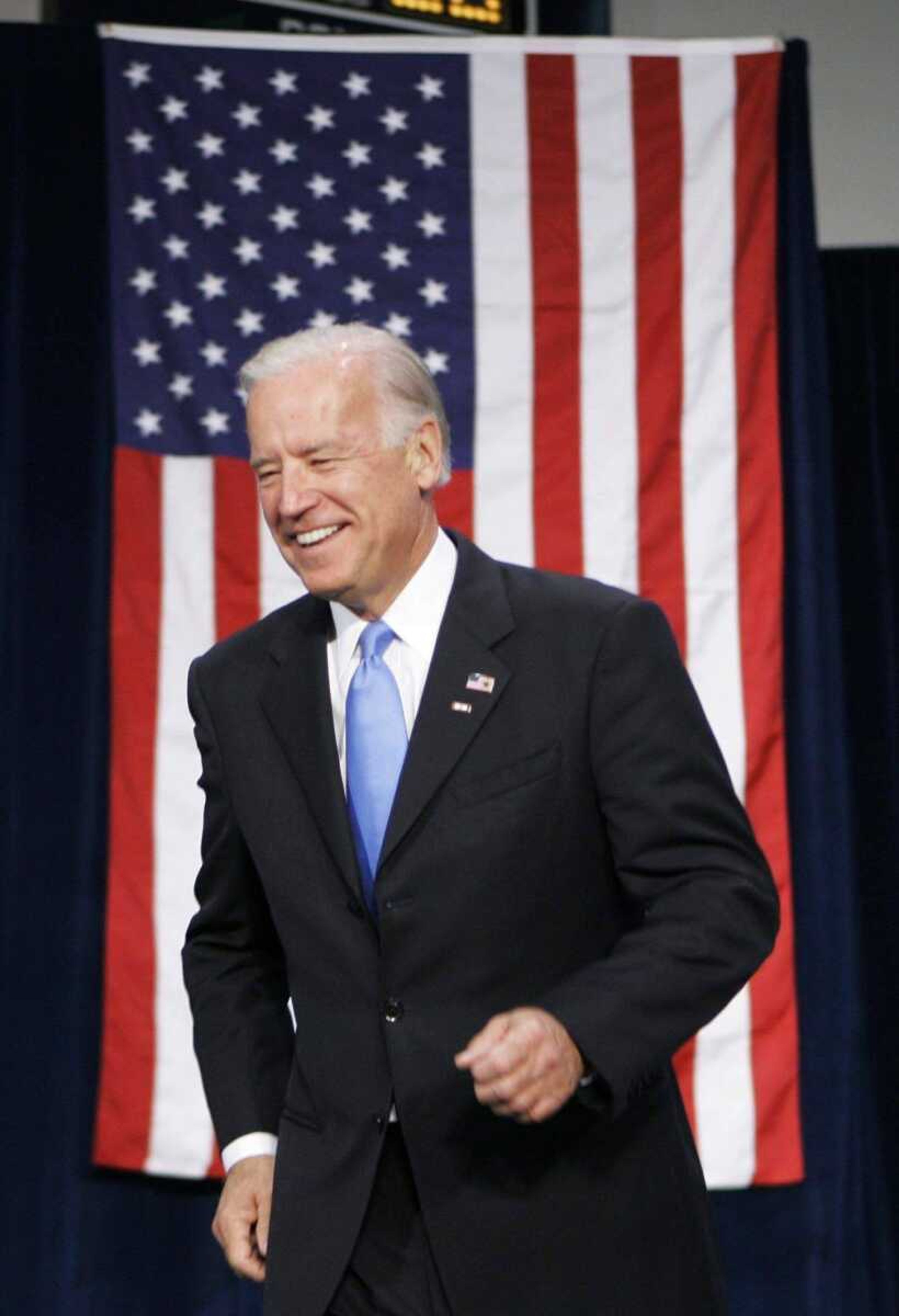 Vice presidential candidate Sen. Joe Biden trots on to the stage during a rally Monday at Longview Community College in Lee's Summit, Mo.<br>ORLIN WAGNER<br>Associated Press