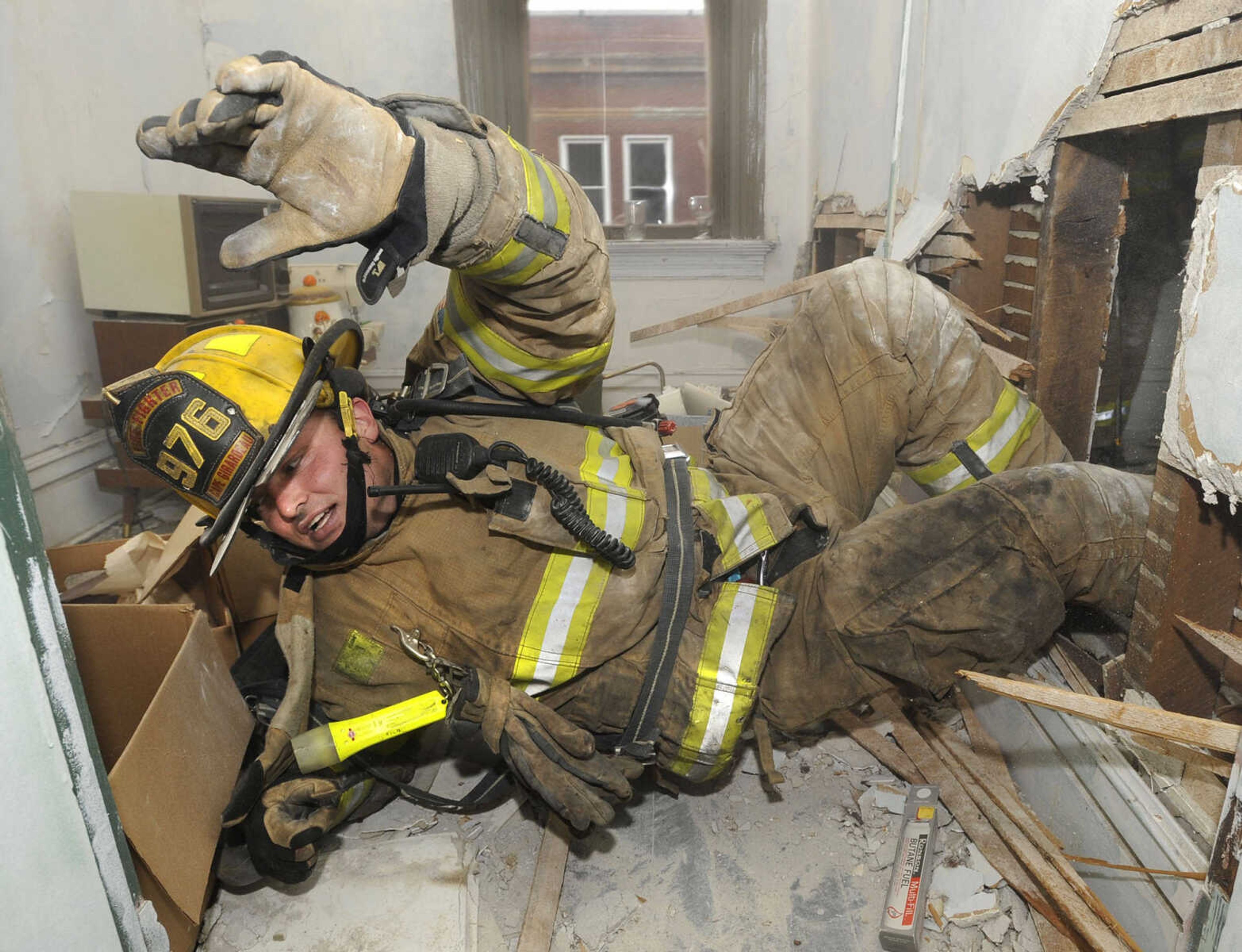 FRED LYNCH ~ flynch@semissourian.com
Cape Girardeau firefighter Jamie Hann practices self-rescue after chopping a hole through a wall inside the vacant building at 501 Broadway Monday, Nov. 21, 2011. The fire department is using the 105-year-old, two-story building for training before its owner, Trinity Lutheran Church, has it razed. The demolition permit was issued Nov. 8 and is good for 45 days.