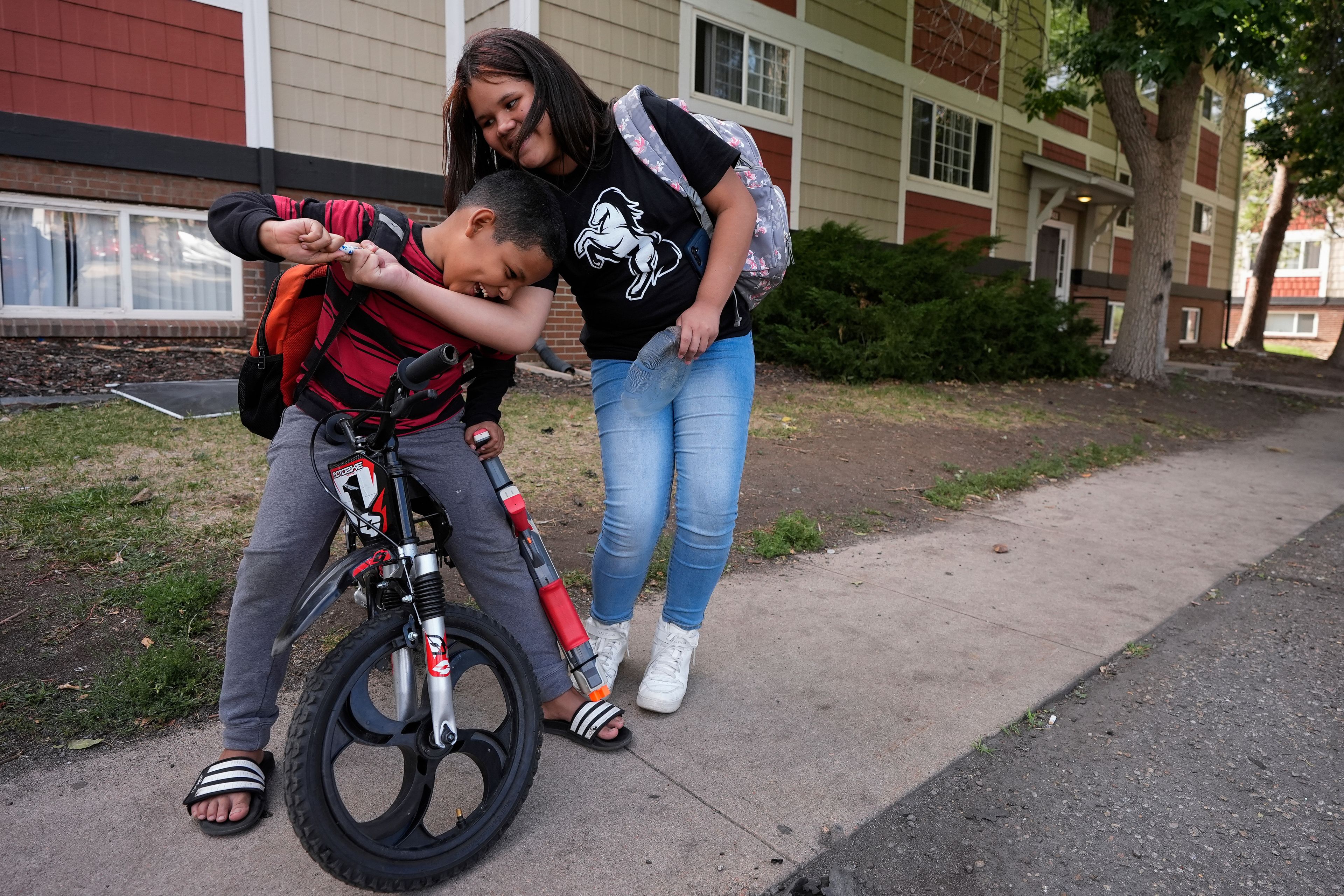 Alisson, right, plays with her nephew Dylan outside their apartment Thursday, Aug. 29, 2024, in Aurora, Colo. (AP Photo/Godofredo A. Vásquez)