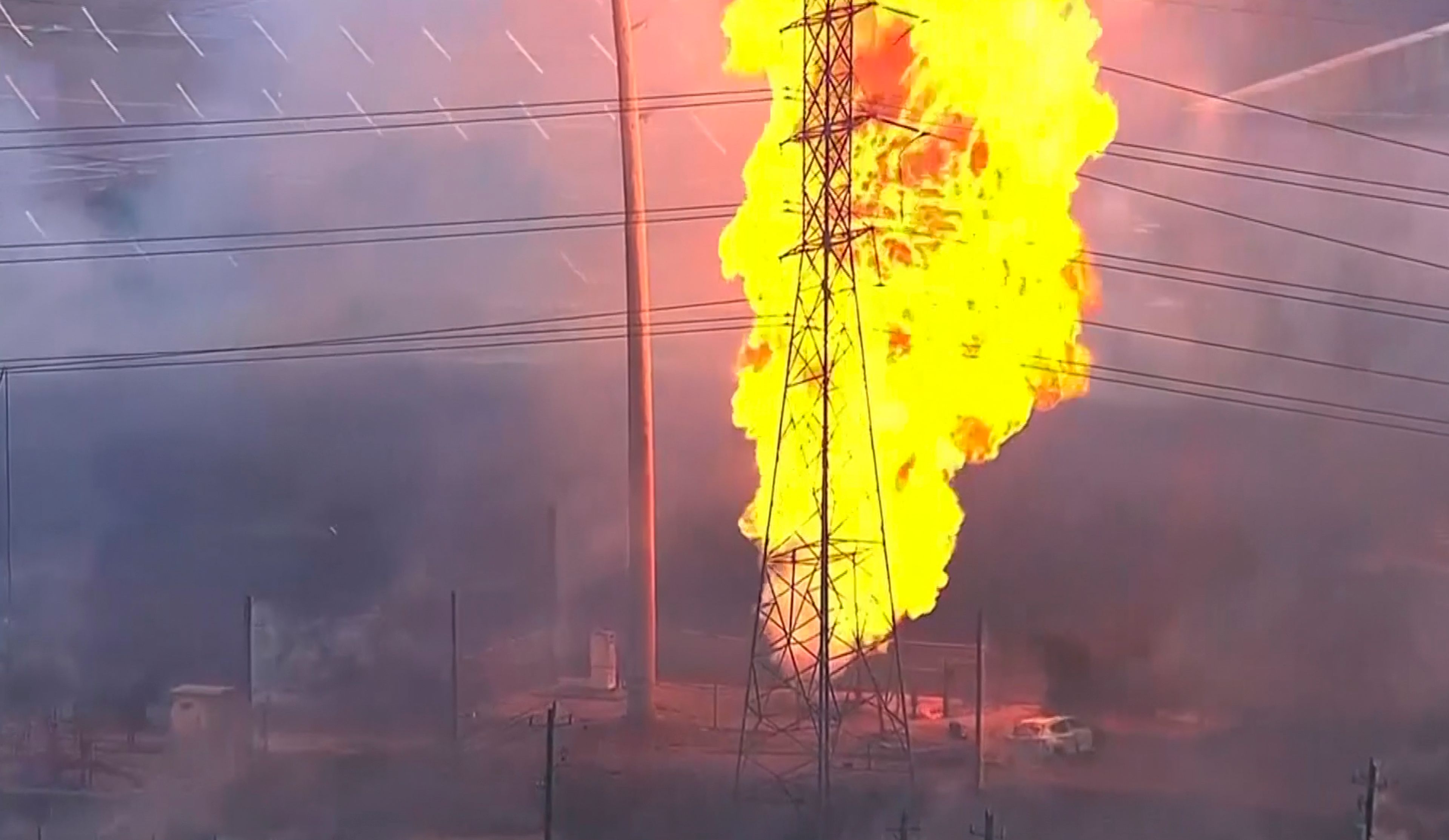 A burned vehicle sits near a pipeline fire in La Porte, Texas, Monday, Sept. 16, 2024. (KTRK via AP)