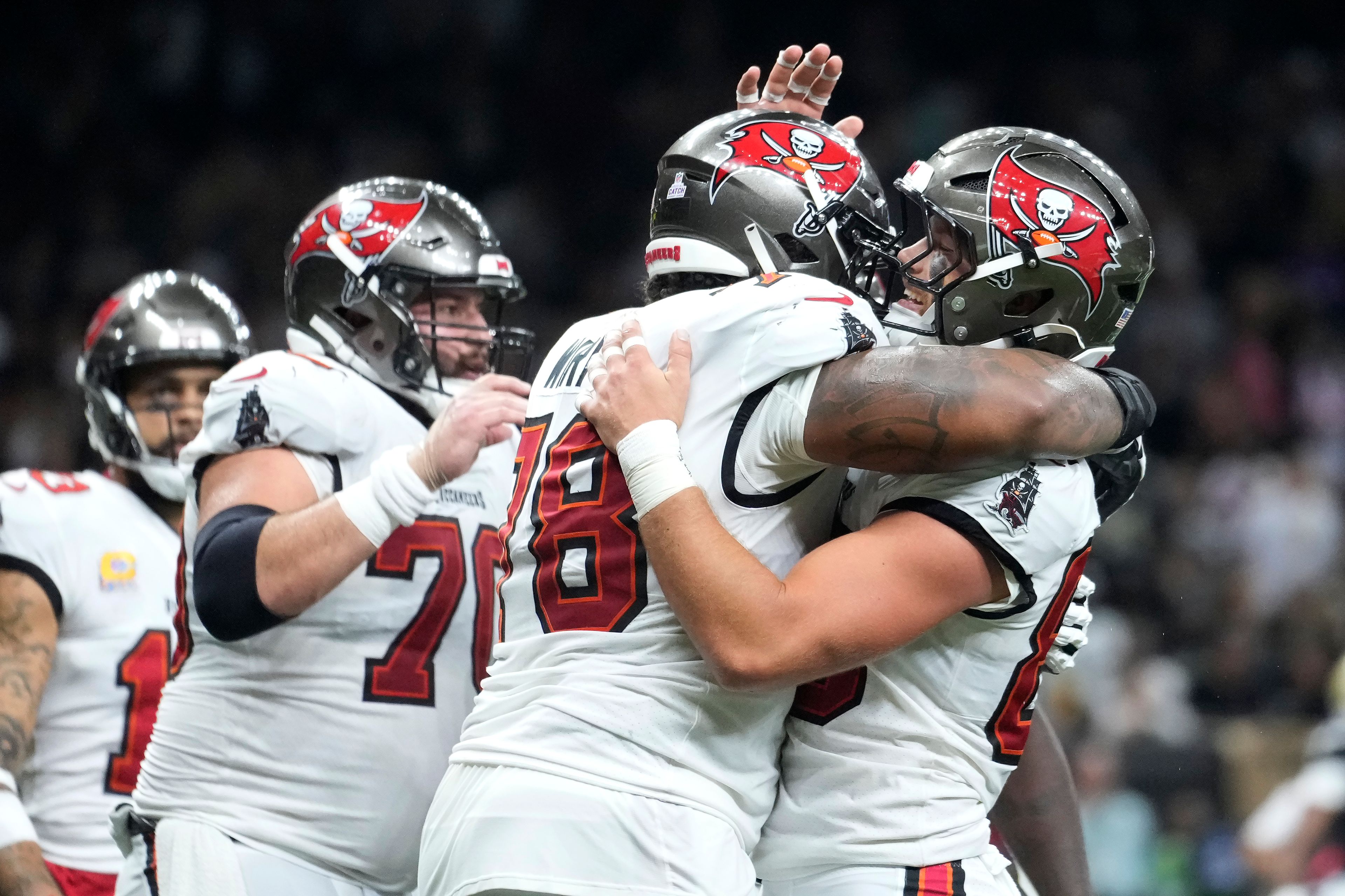 Tampa Bay Buccaneers tight end Cade Otton, right, is congratulated by offensive tackle Tristan Wirfs (78) and teammates after scoring against the New Orleans Saints during the second half of an NFL football game in New Orleans, Sunday, Oct. 13, 2024. (AP Photo/Michael Conroy)