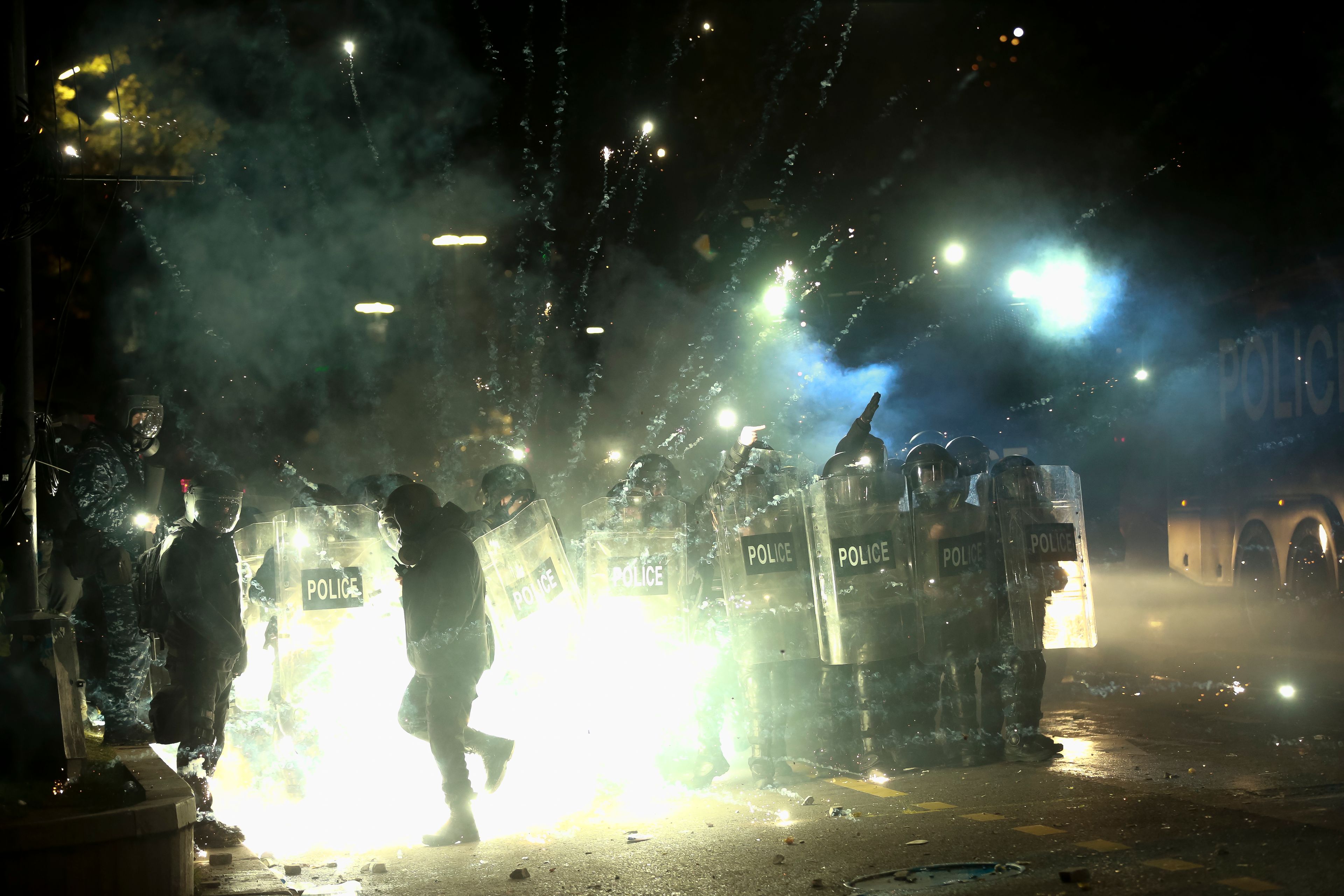 Demonstrators use firecrackers against police as police block a street to prevent protesters rallying against the government's decision to suspend negotiations on joining the European Union for four years, outside the parliament's building in Tbilisi, Georgia, early Saturday, Nov. 30, 2024. (AP Photo/Zurab Tsertsvadze)