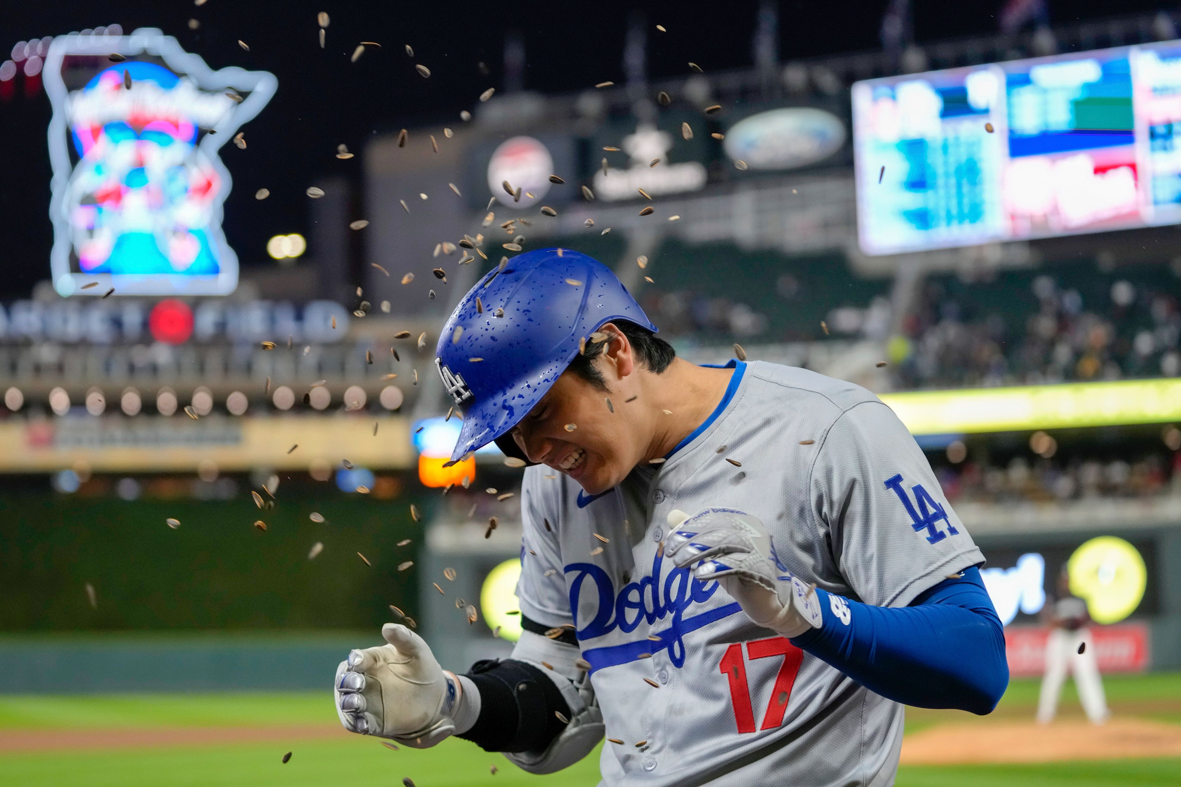 Los Angeles Dodgers designated hitter Shohei Ohtani is sprinkled with sunflower seeds after hitting a solo home run during the seventh inning of a baseball game against the Minnesota Twins, Monday, April 8, 2024, in Minneapolis. (AP Photo/Abbie Parr)