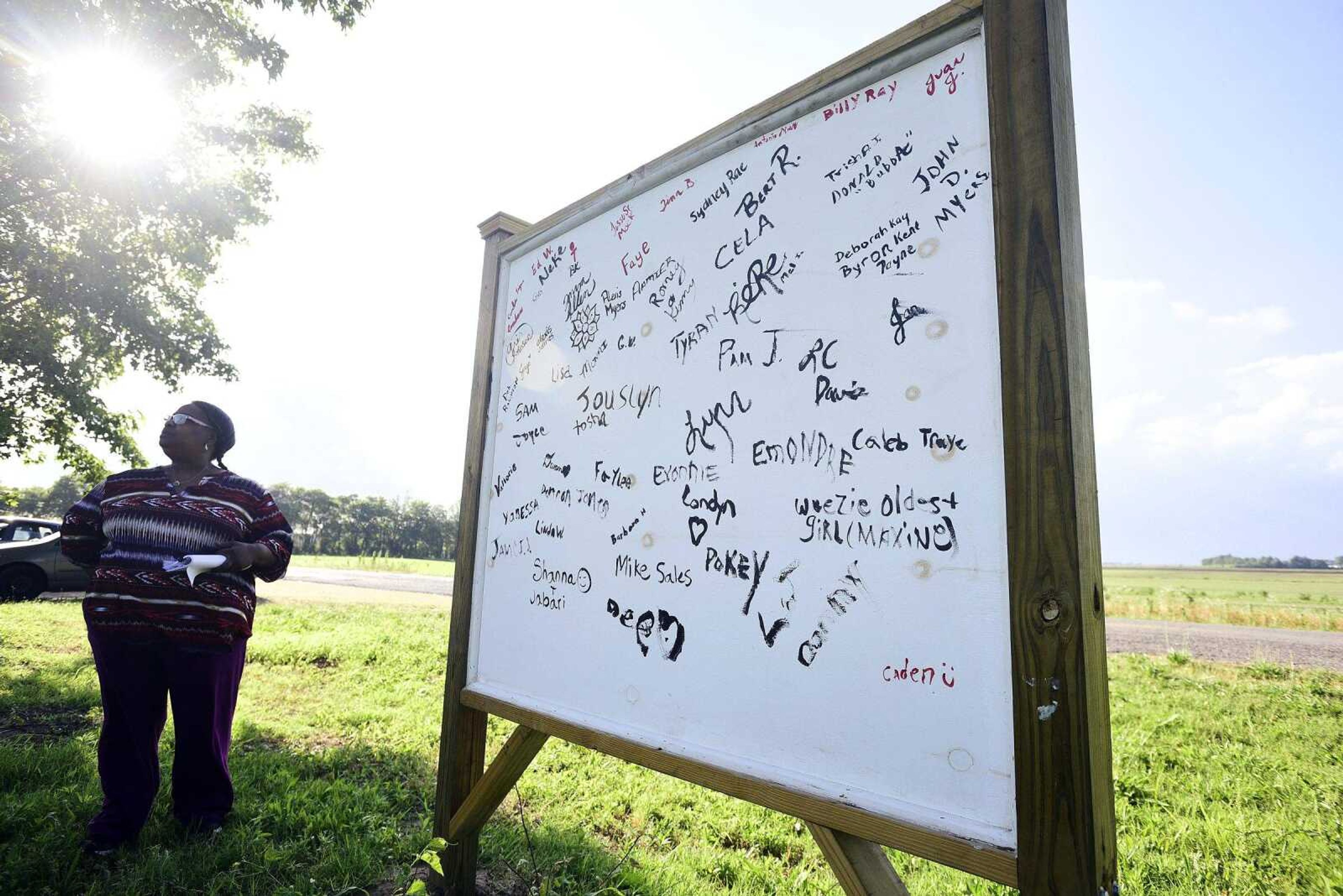 Debra Robinson Tarver stands Monday in the now-vacant Mississippi County town she called home for the majority of her life. Former Pinhook residents autographed a newly erected Pinhook sign.