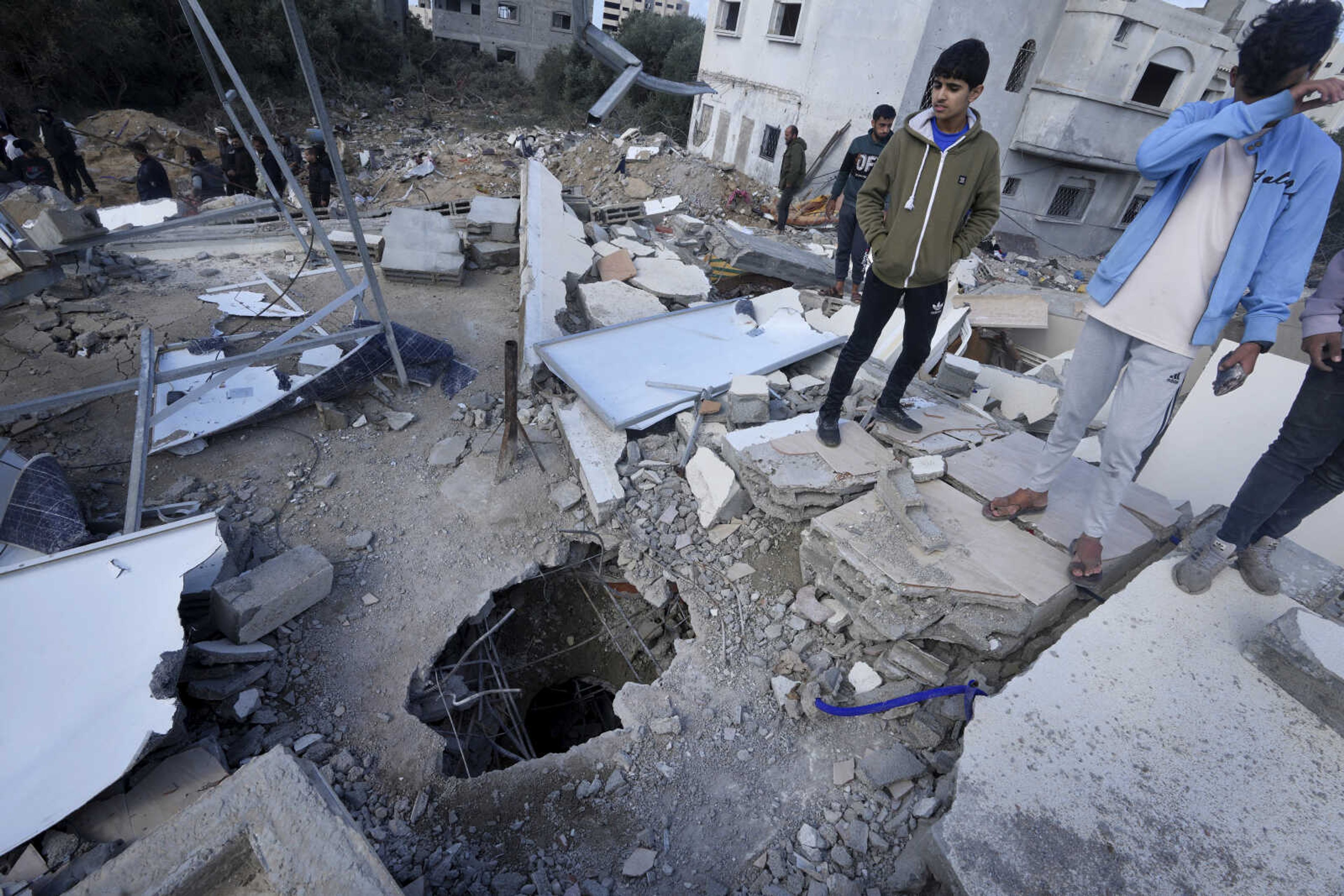 Palestinians look at the building of the Darwesh family, killed in the Israeli bombardment of the Gaza Strip, in Nusseirat refugee camp, central Gaza Strip, Monday, Nov. 20, 2023. (AP Photo/Adel Hana)