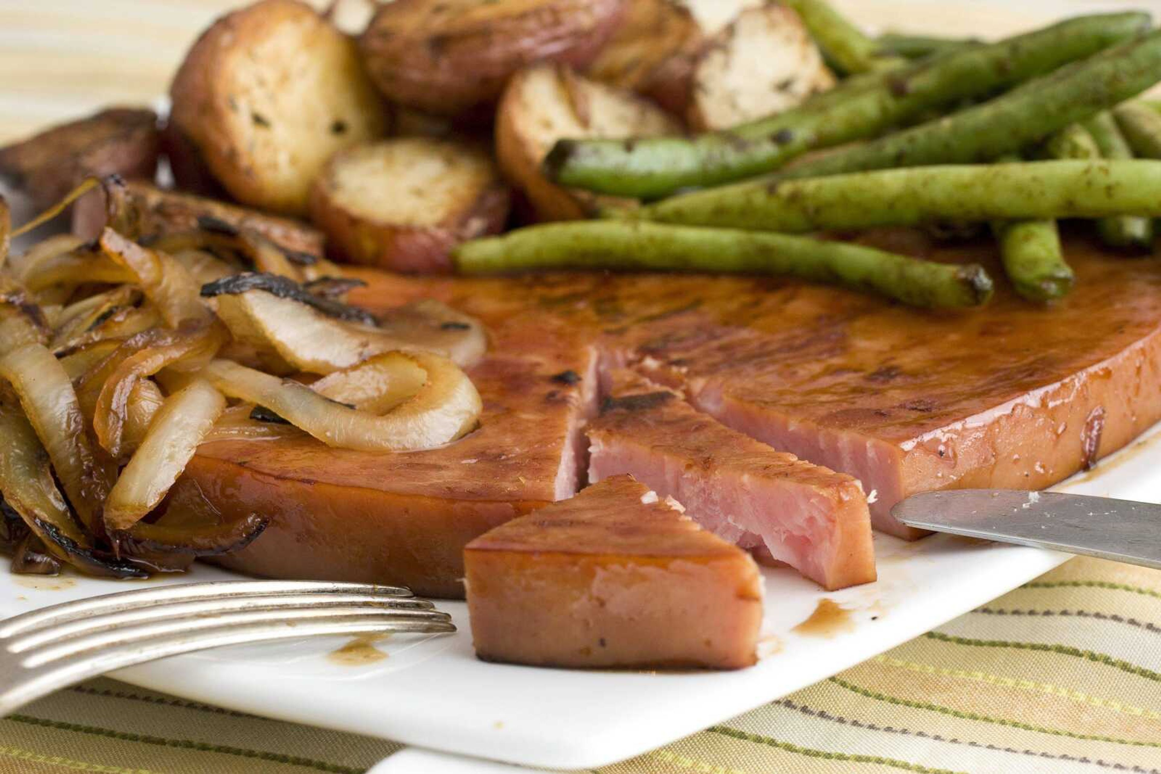 Ham steaks are a quick and versatile way to get a ham dinner on the plate. These maple ham steaks with roasted potatoes and green beans require little preparation. (Larry Crowe ~ Associated Press)