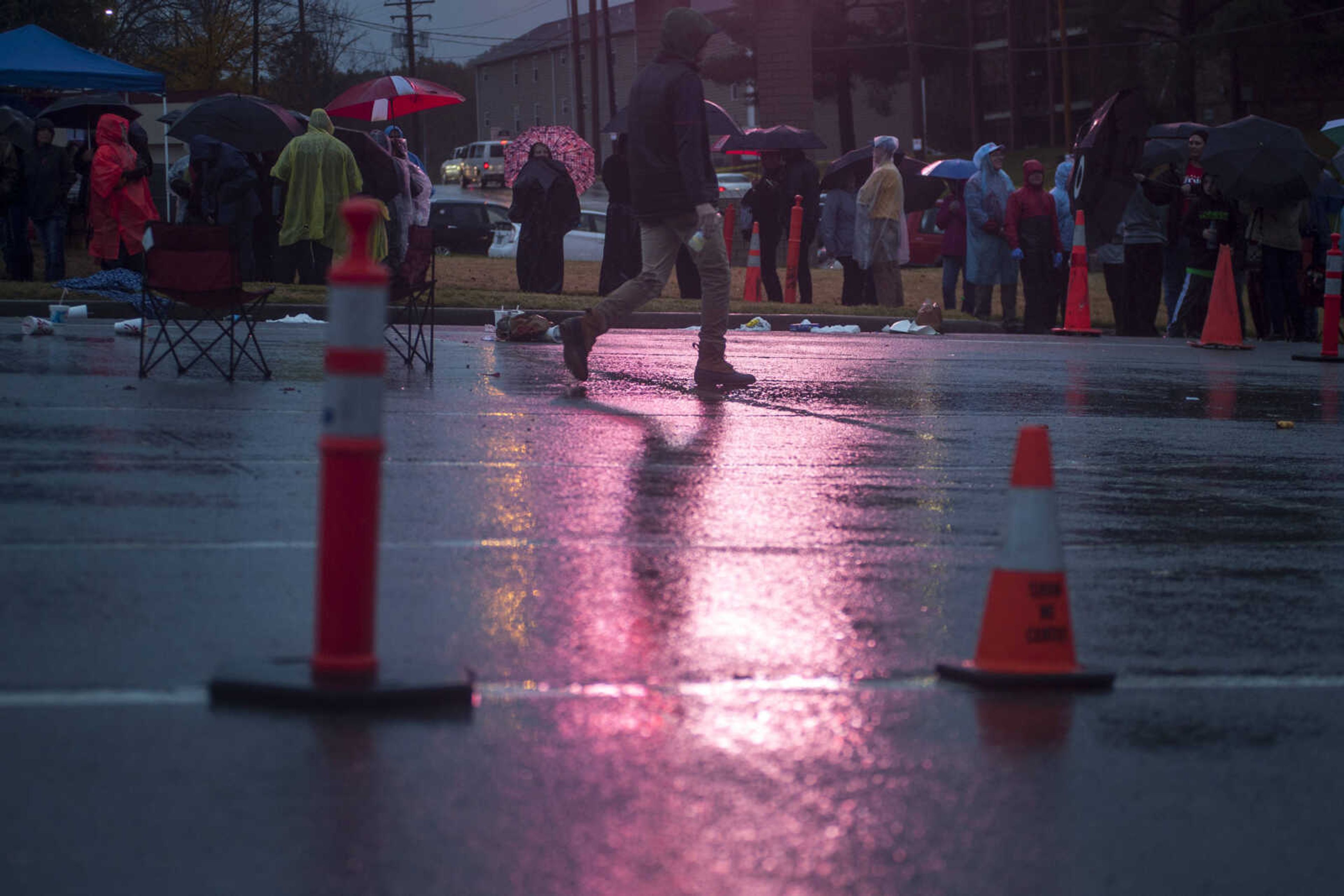 Attendees wait in the rain to watch a rally for President Donald Trump at the Show Me Center Monday.