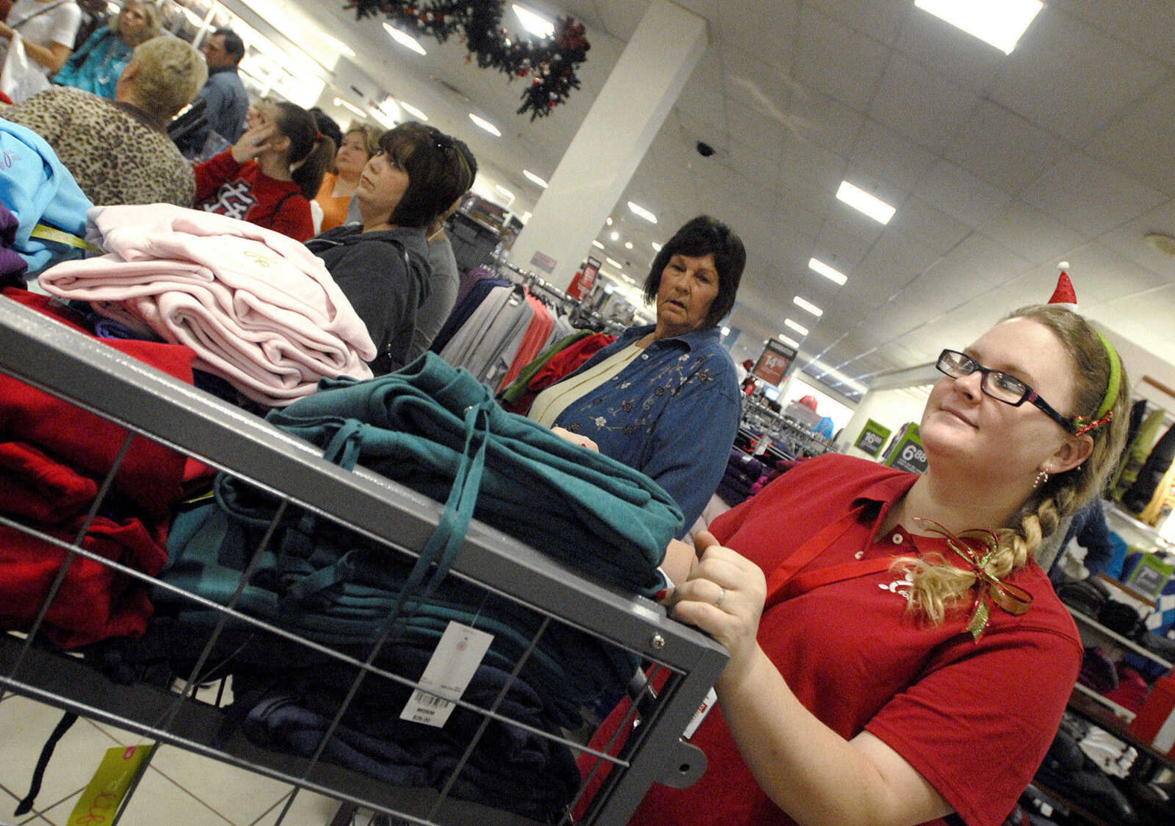 LAURA SIMON ~ lsimon@semissourian.com
JCPenney employee Stephanie Buttelwerth wheels a cart of fleece sweaters for restocking the shelves Friday, November 25, 2011 in Cape Girardeau.