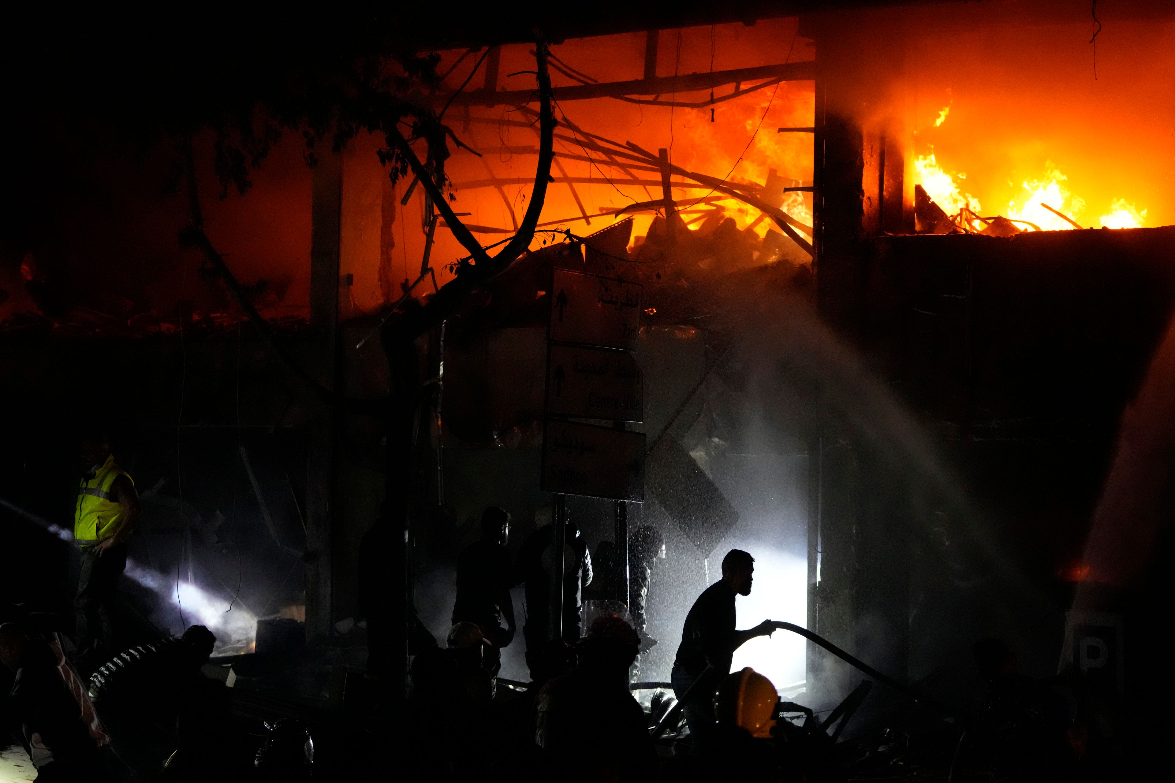 Civil defense workers extinguish a fire at the site of an Israeli airstrike in Beirut, Sunday, Nov. 17, 2024. (AP Photo/Hassan Ammar)