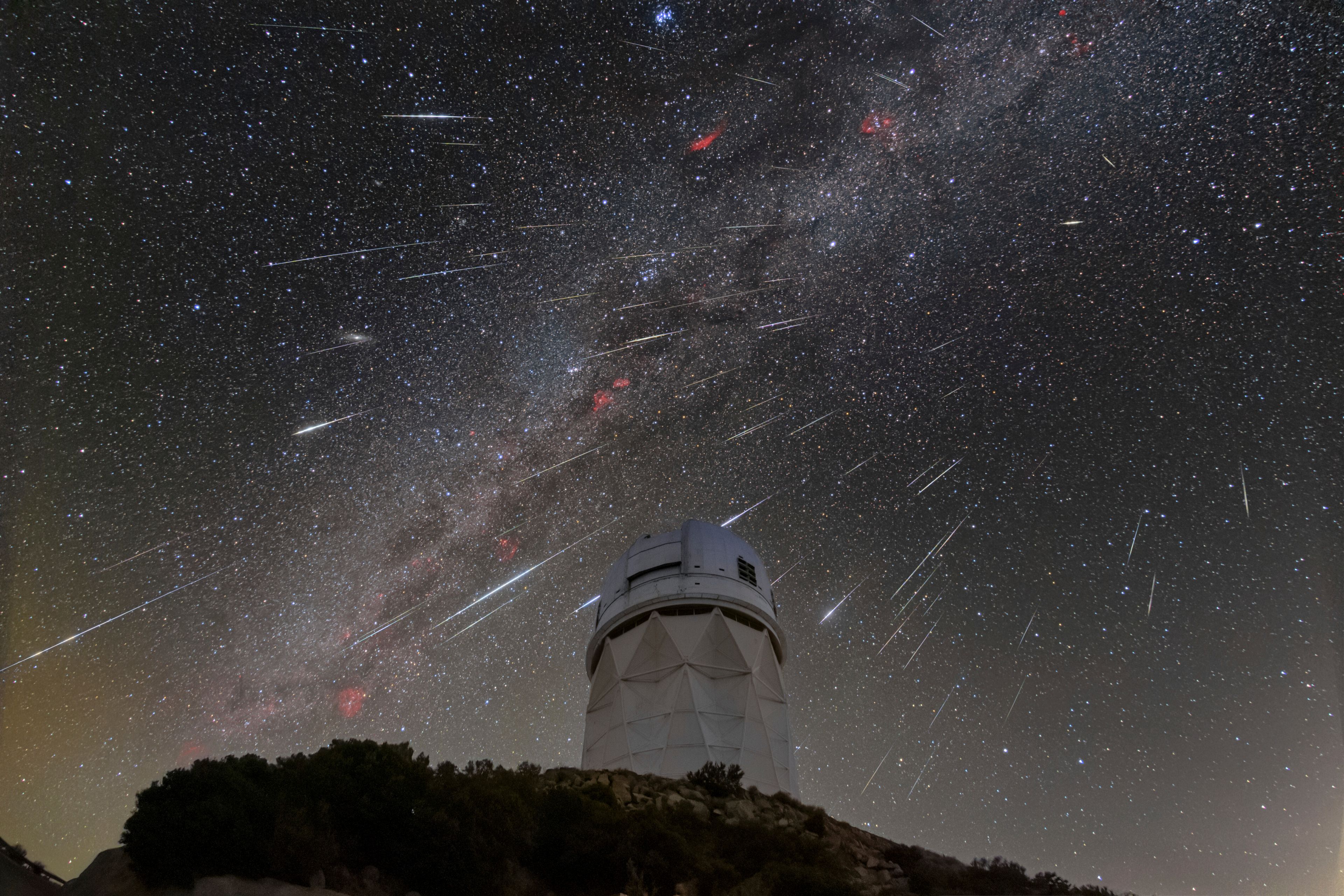 This Dec. 14, 2023 image made available by NOIRLab shows meteors from the Geminid meteor shower streaking across the sky above the Nicholas U. Mayall Telescope at Kitt Peak National Observatory (KPNO), a Program of NSF's NOIRLab, in Tucson, Ariz. (NSF's NOIRLab via AP)