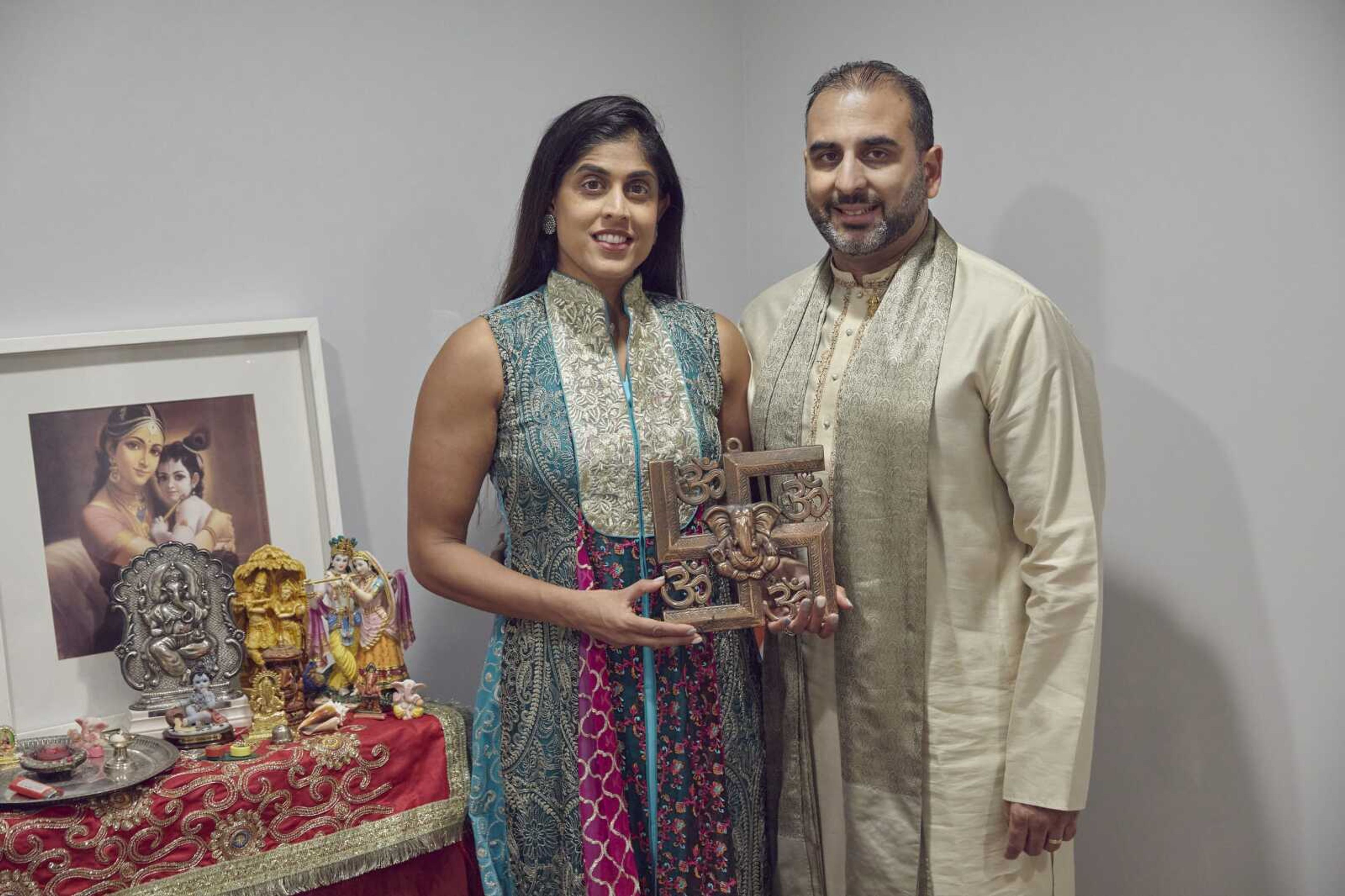 Sheetal Deo and her husband, Sanmeet Deo, hold a Hindu swastika symbol Sunday, Nov. 13, in their home in Syosset, New York. Hindus, Buddhists and Native Americans are trying to rehabilitate the swastika, a symbol of peace and prosperity, and to restore it to a place of sanctity in their faiths.