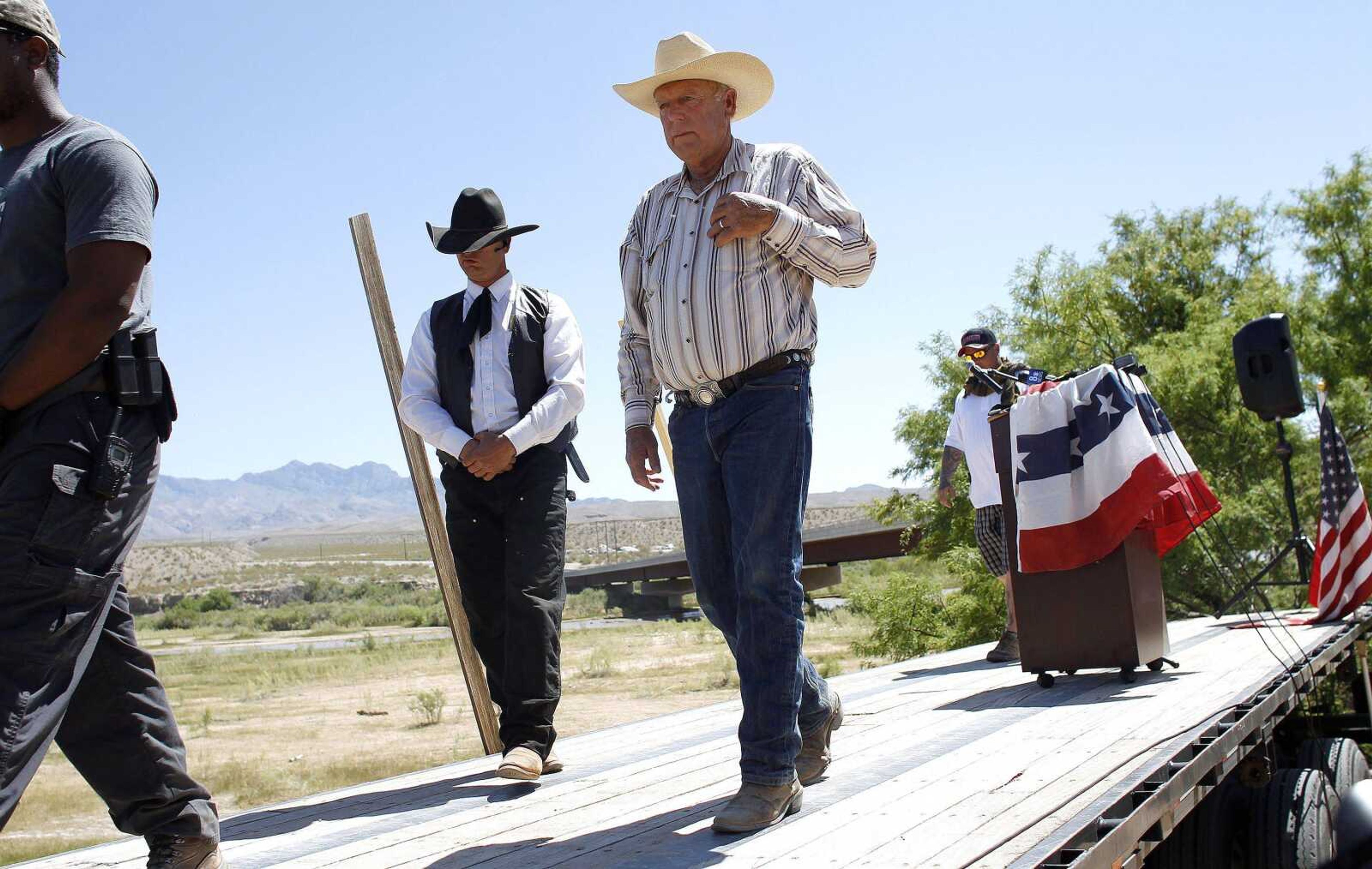 Rancher Cliven Bundy, in light hat, walks off stage after speaking at a news conference Thursday near Bunkerville, Nev. (John Locher ~ Las Vegas Review-Journal)