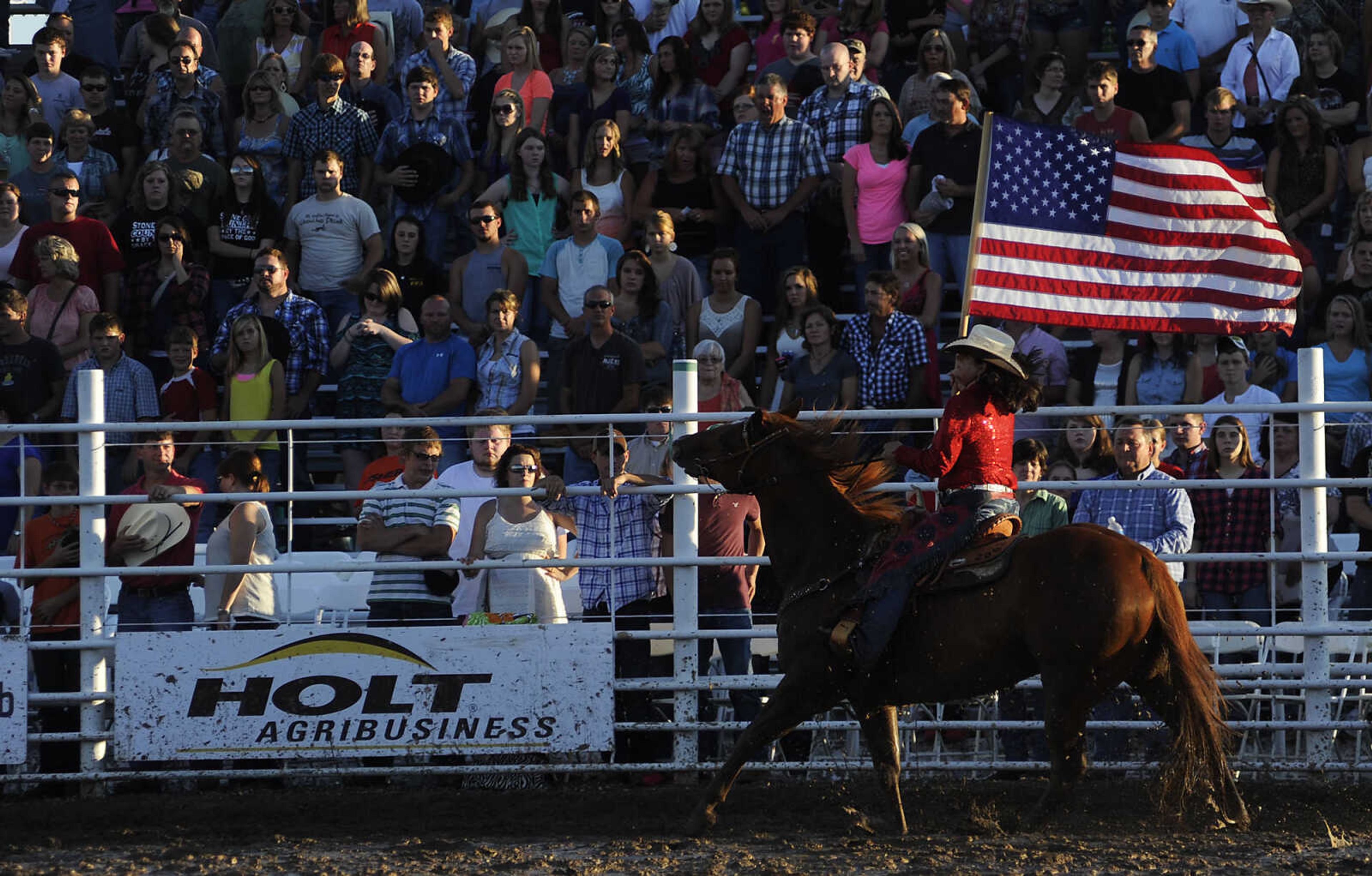 A rider with the American Flag circles the arena as the National Anthem plays before the Sikeston Jaycee Bootheel Rodeo Wednesday, August 7, in Sikeston, Mo.