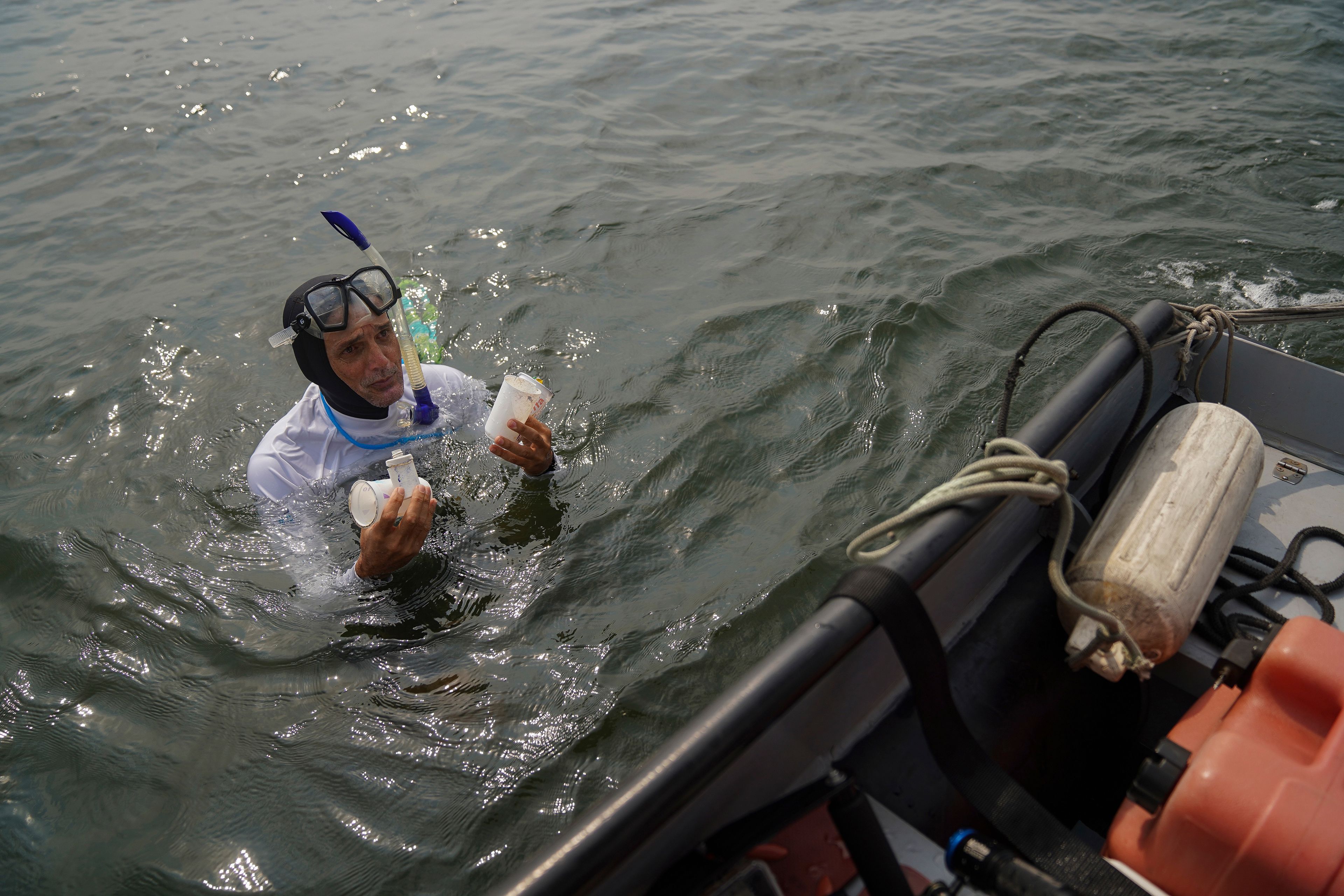 Biologist and filmmaker Ricardo Gomes collects trash in Guanabara Bay as part of World Cleanup Day activities, in Rio de Janeiro, Saturday, Sept. 21, 2024. (AP Photo/Hannah-Kathryn Valles)