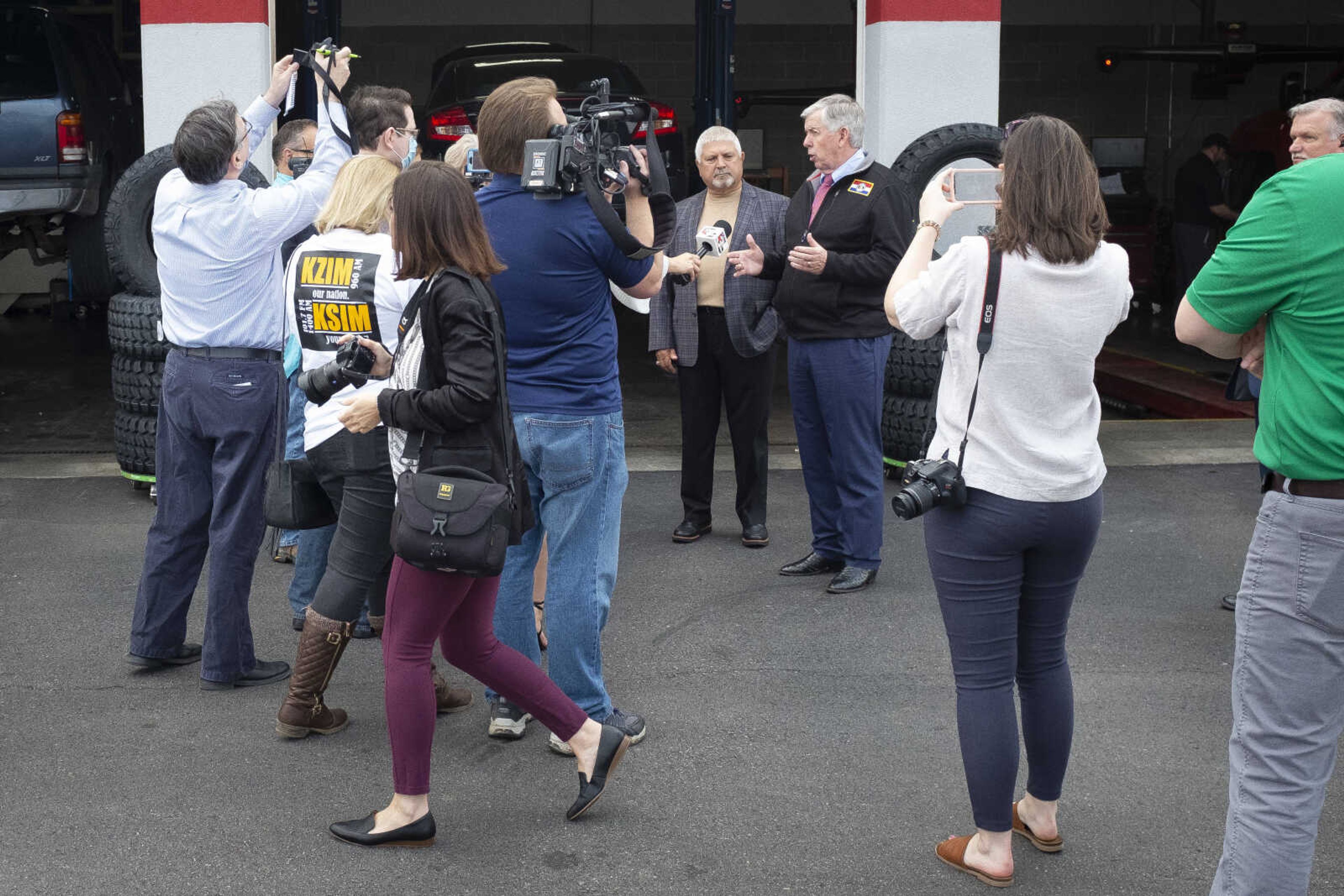 Missouri Gov. Mike Parson, in black coat and facing cameras, speaks next to Cape Girardeau mayor Bob Fox as the governor makes a visit Thursday, May 14, 2020, at Plaza Tire Service in Cape Girardeau. Following his visit, Gov. Parson returned to Jefferson City for a briefing to give updates on COVID-19 in the state.