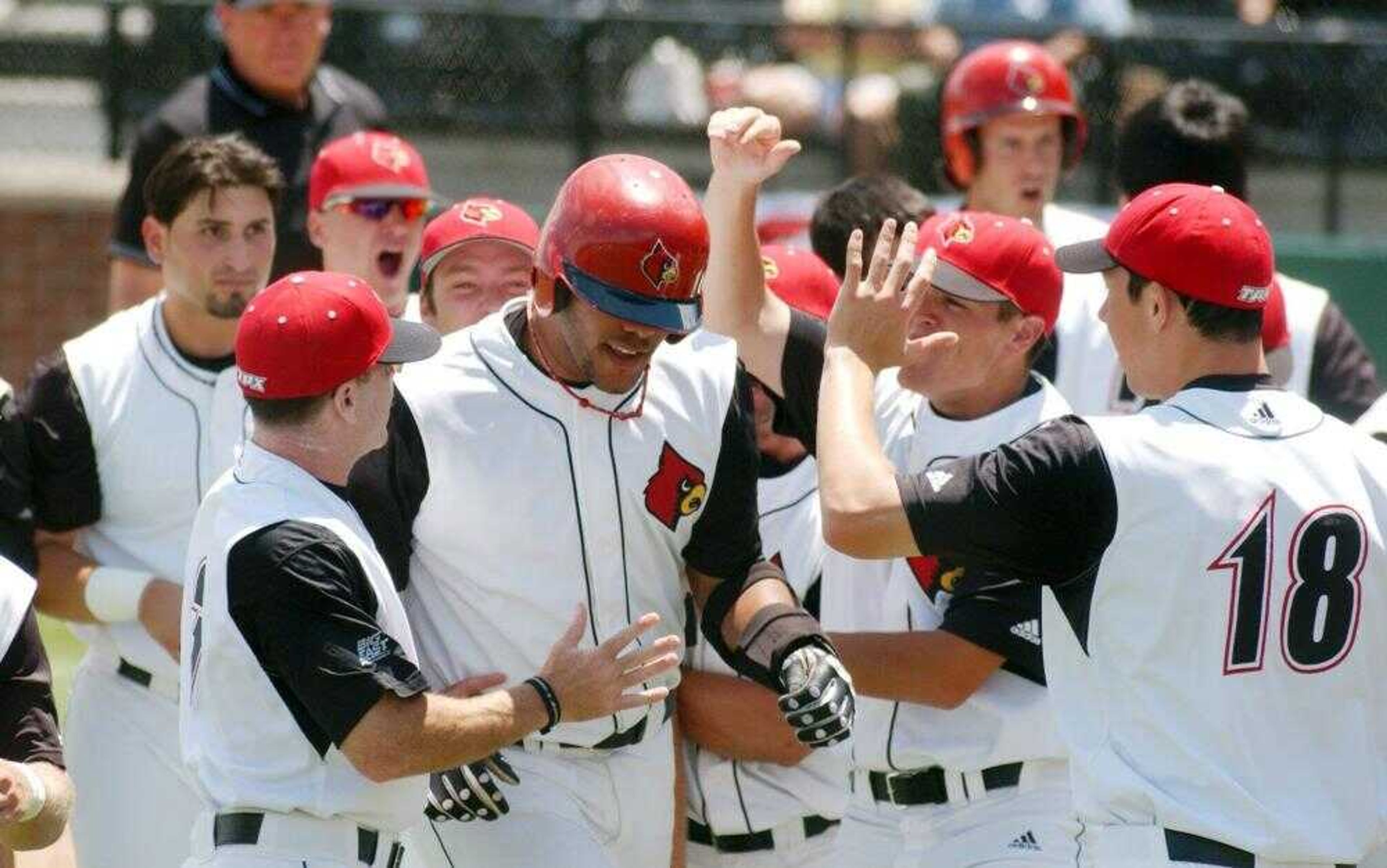 Louisville's Chris Dominguez, center, was congratulated by teammates after he hit a first-inning grand slam Monday against Missouri.